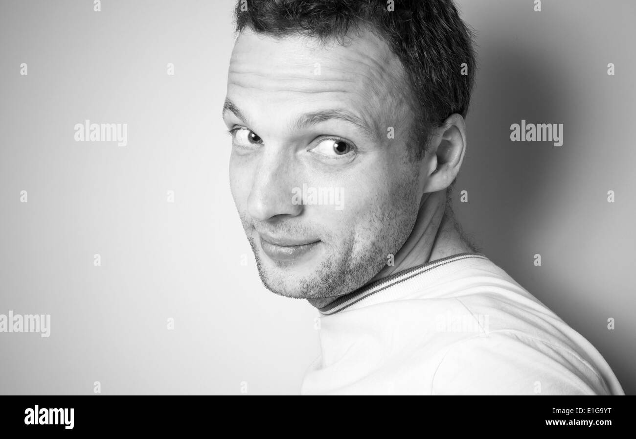 Lächelnder junge kaukasischen Mann im weißen T-shirt, monochrome portrait Stockfoto