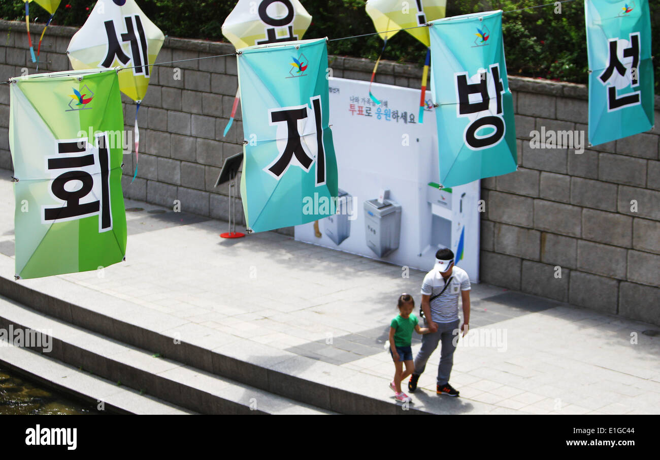 Seoul, Südkorea. 4. Juni 2014. Menschen zu Fuß passieren Wahlplakate in Seoul, Südkorea, 4. Juni 2014. Südkoreaner werden insgesamt 3.952 Beamte, darunter 17 Bürgermeister, Provinzgouverneure und Superintendenten und 226 Leiter der Low-Level-Verwaltungseinheiten sowie einige 3.700 lokale Ratsmitglieder wählen. Die Abstimmung begonnen von 06:00 in 13.665 Wahllokalen bundesweit, bis 18:00, nach dem nationalen Wahl Kommission (NEC). Bildnachweis: Yao Qilin/Xinhua/Alamy Live-Nachrichten Stockfoto