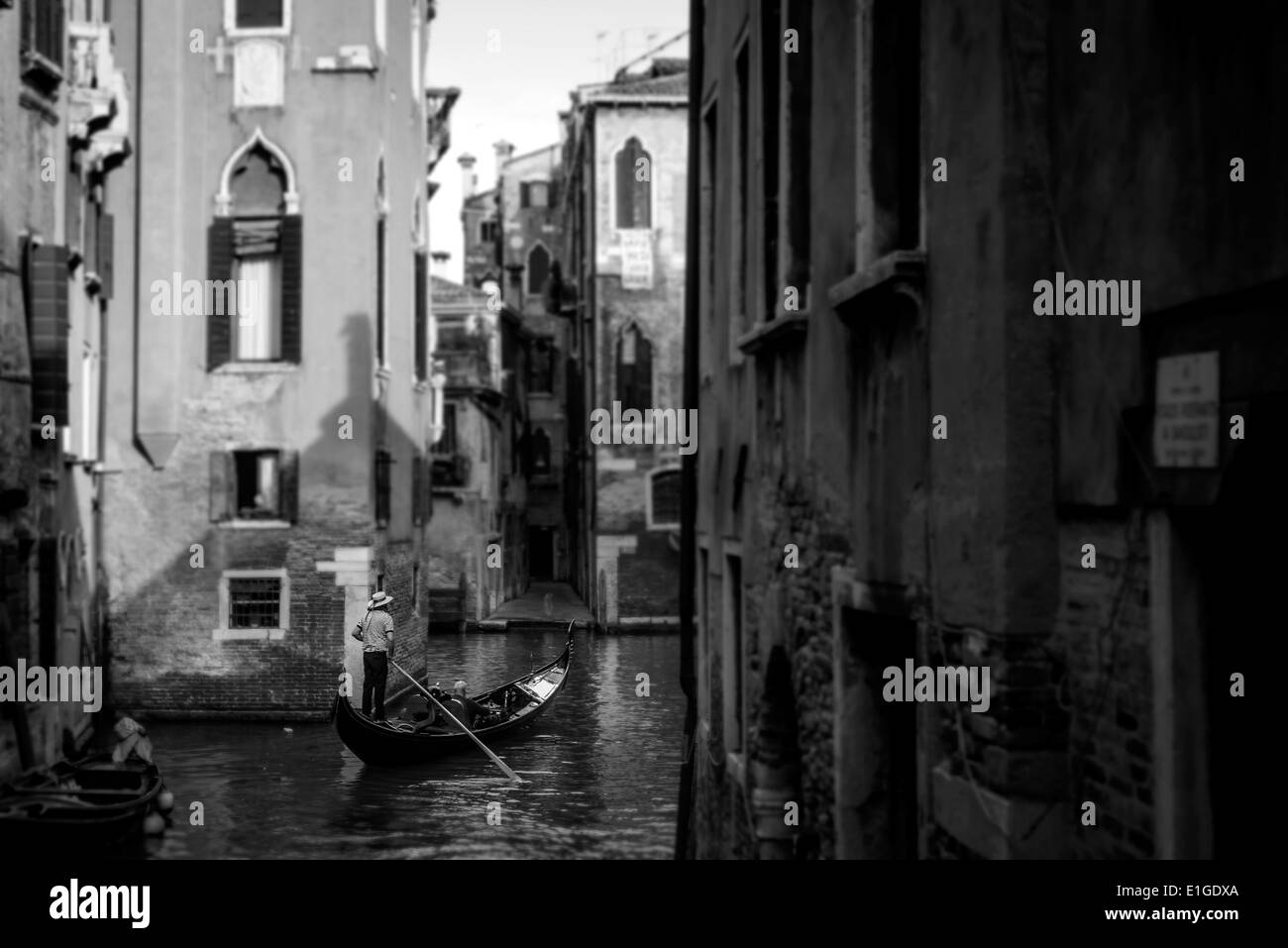 Gondoliere, die die Touristen in einer Gondel in einigen kleinen Kanal in Venedig Stockfoto