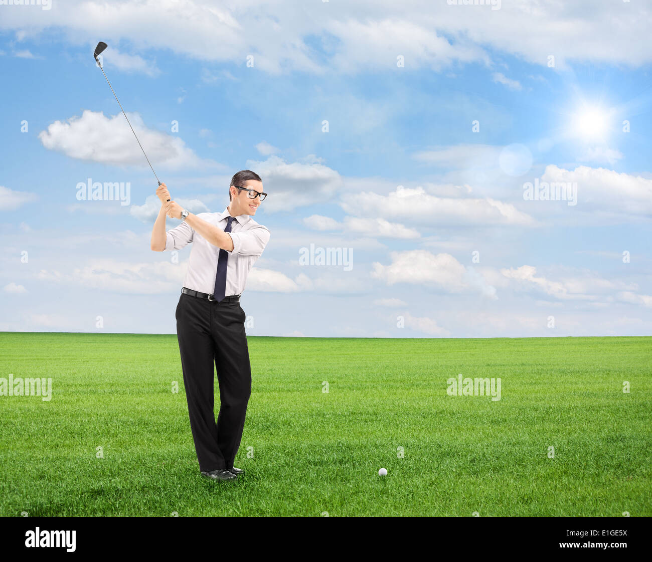 Junger Mann, Golfen auf einem Feld isoliert auf weißem Hintergrund mit Tilt-Shift-Objektiv geschossen Stockfoto