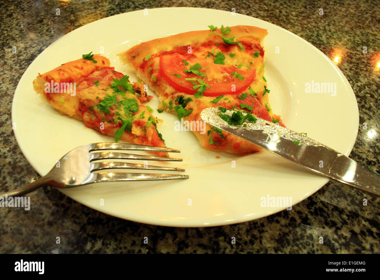 zwei Stücke von leckere Pizza mit Messer und Gabel Stockfoto