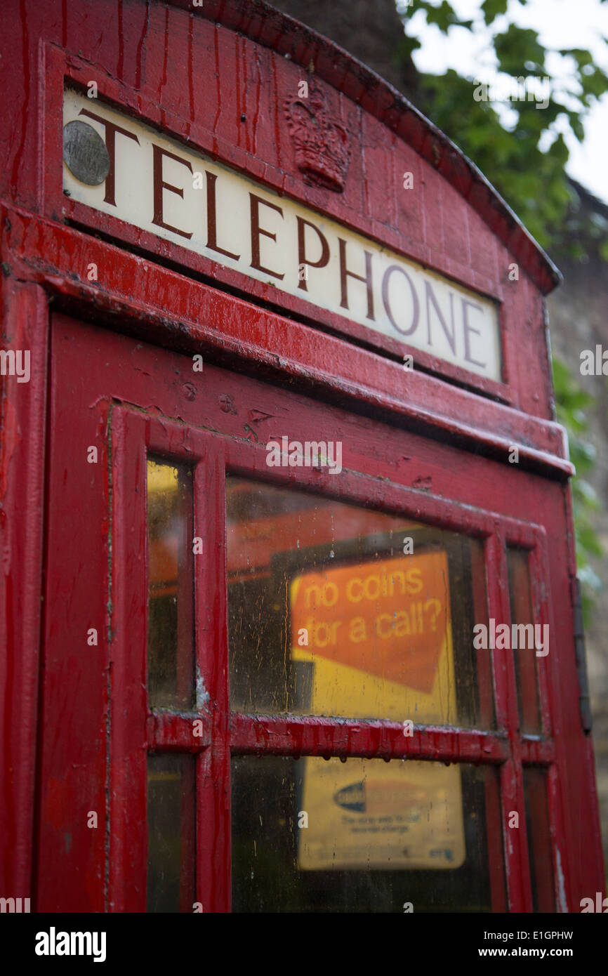 Red verwitterten Telefonzelle trat in die Bäume auf einem nass und regnerisch Tag in Lincoln, Lincolnshire. Stockfoto