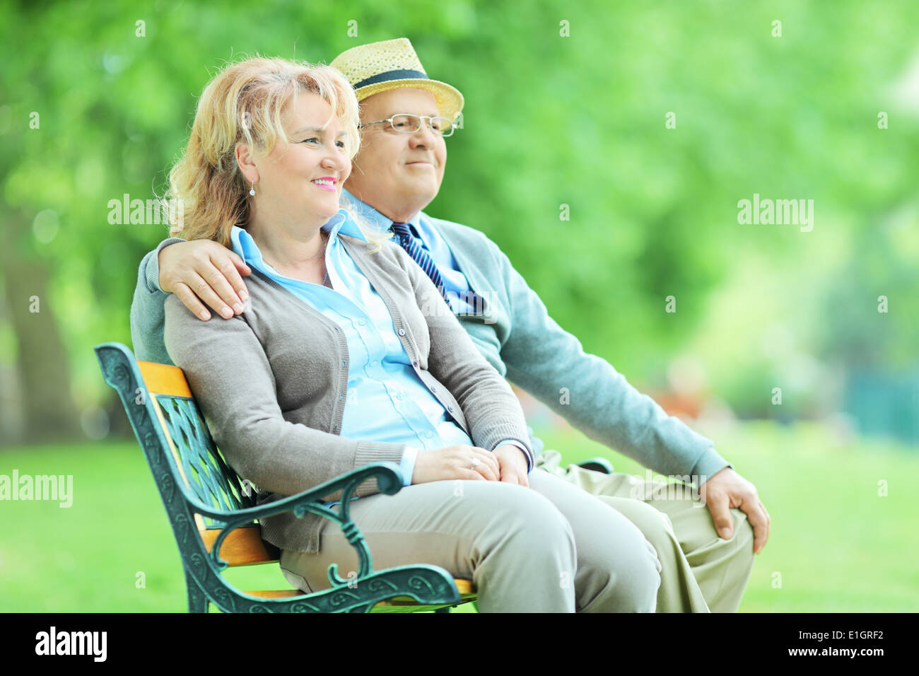Entspannte älteres Paar sitzt auf einer Holzbank im park Stockfoto