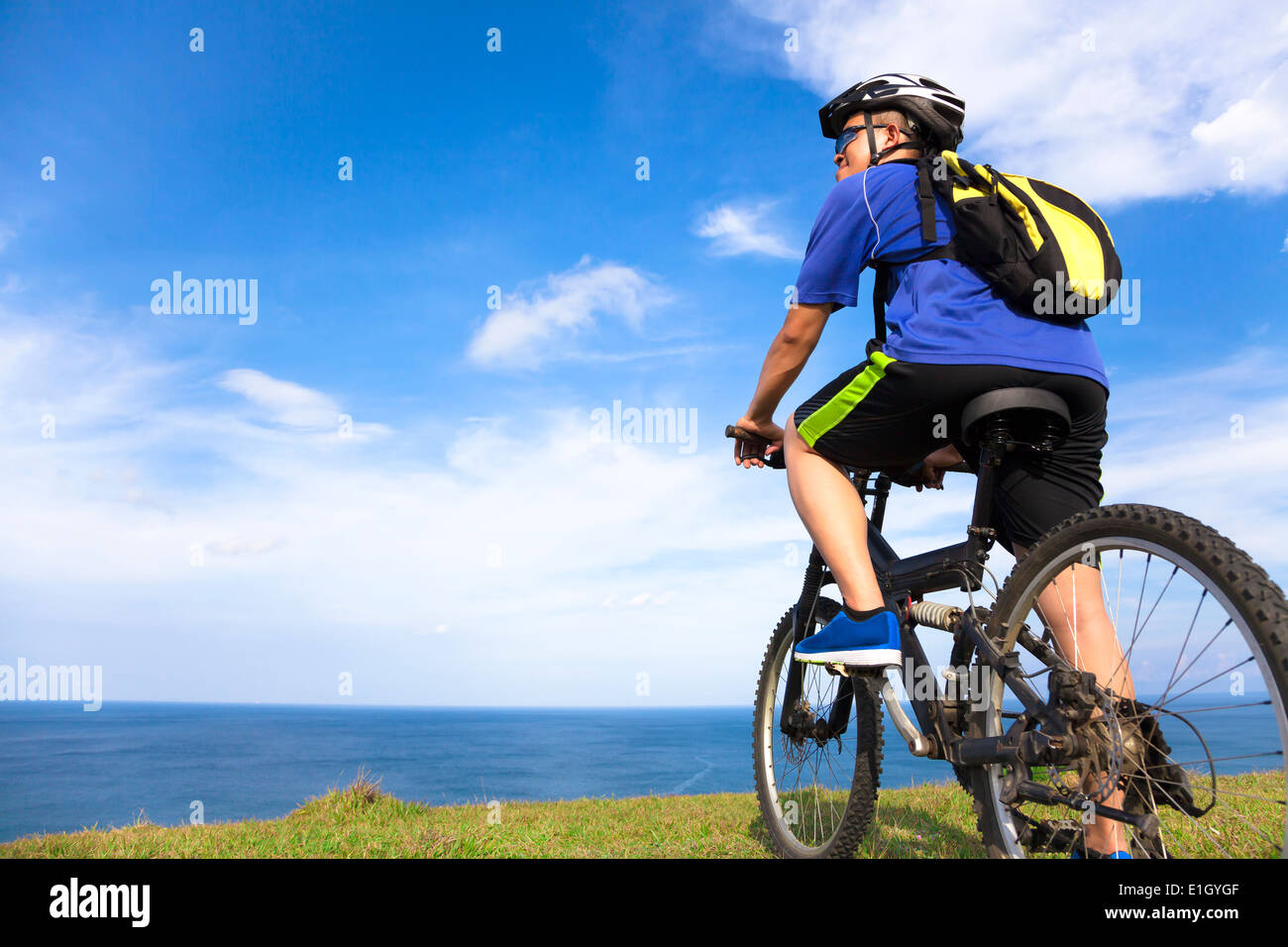 junger Mann sitzt auf einem Mountainbike und auf der Suche nach dem Meer Stockfoto
