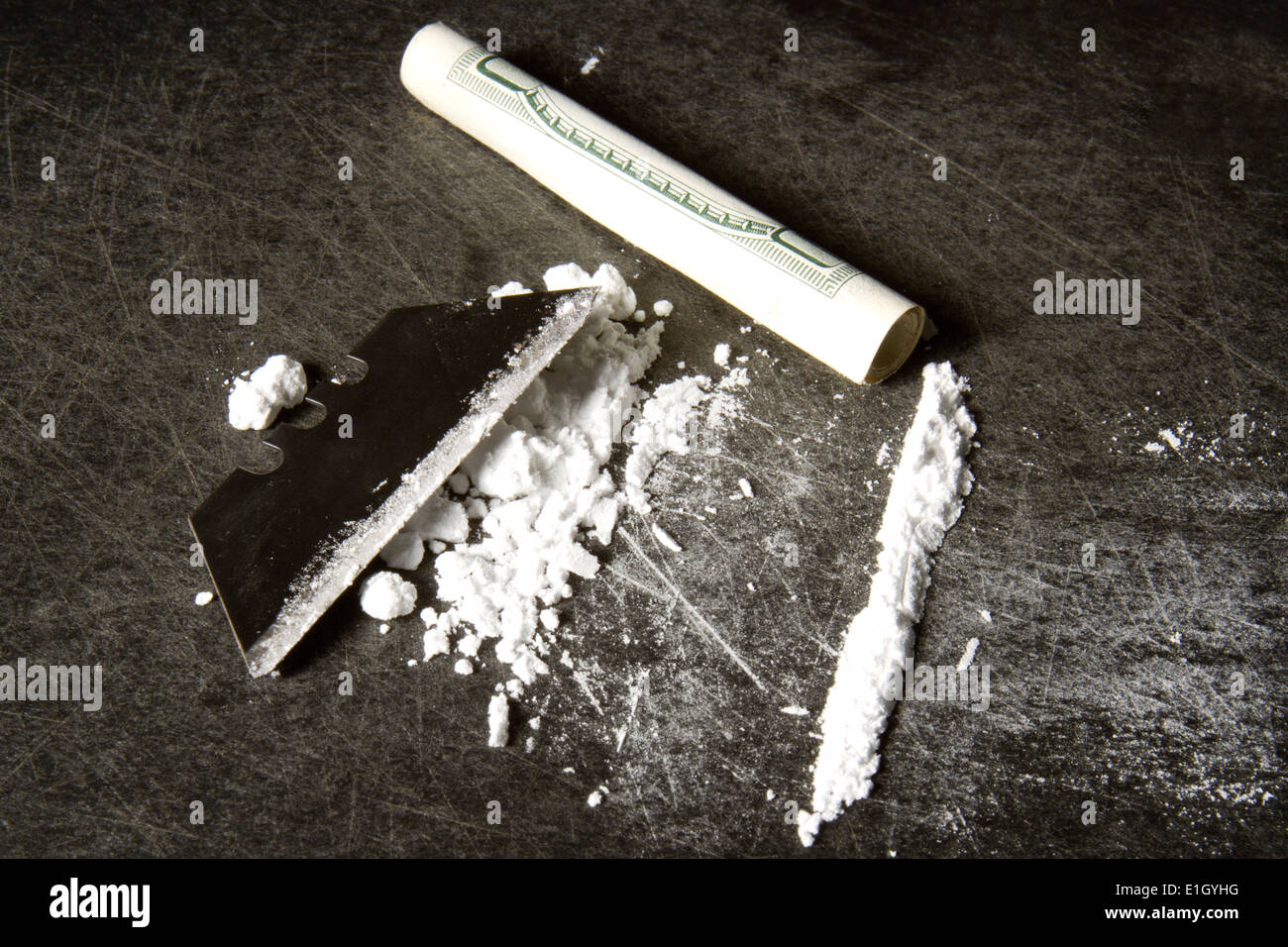 Pulverisierte Kokain in einer Linie mit Rasierklinge vorbereitet und aufgerollt, hundert-Dollar-Schein Stockfoto