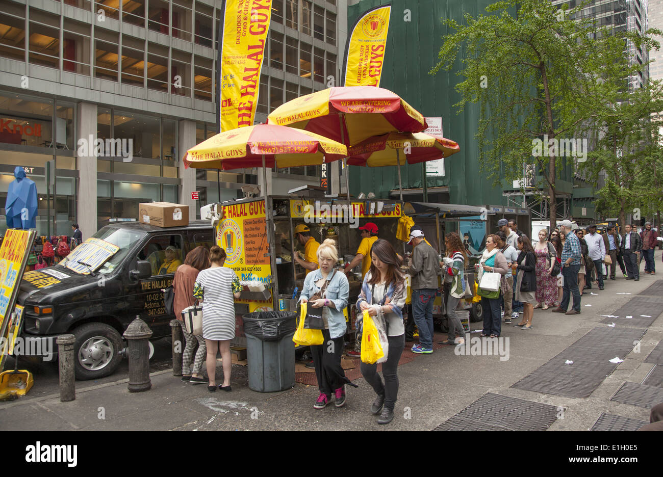 Menschen richten Sie zum Essen in das ungeheuer populär Halal Jungs Essen LKW im 53rd St. & 6th Avenue in Midtown Manhattan. Stockfoto