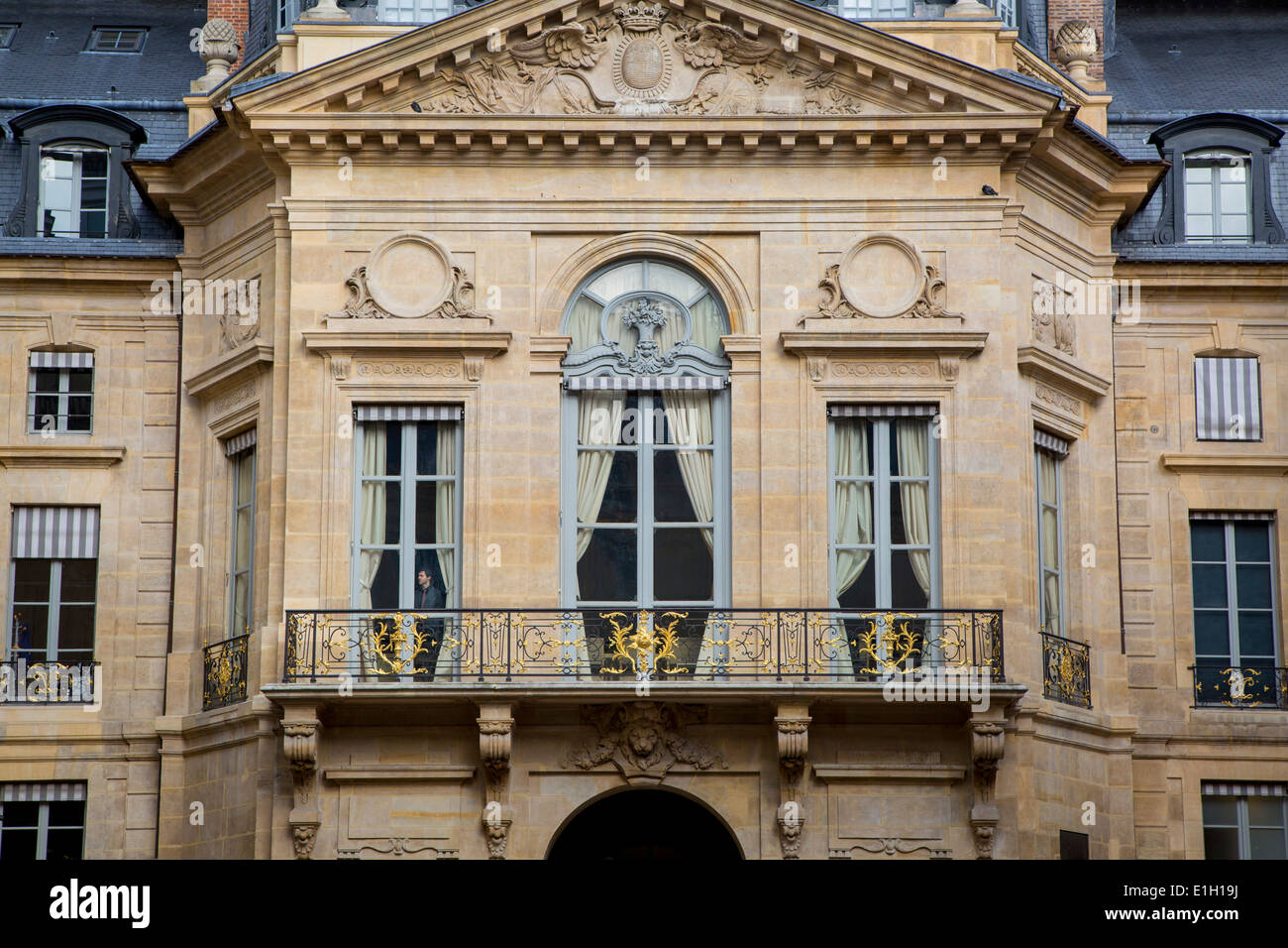 Mann aus dem Fenster des Ministeriums für Kultur und Kommunikation Gebäudes befestigt, Palais Royal, Paris Frankreich Stockfoto