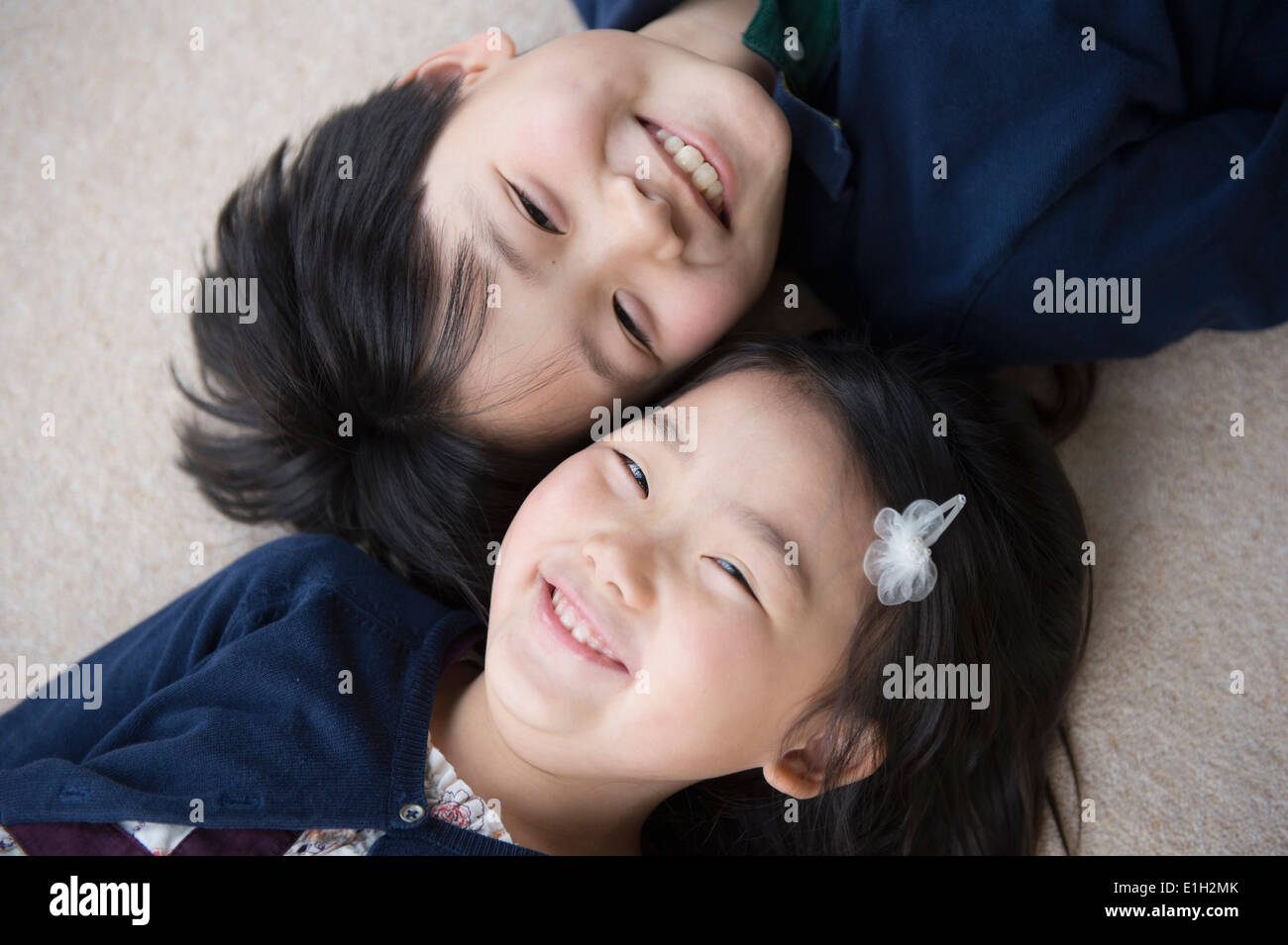 Porträt von Bruder und Schwester liegen auf Teppich Stockfoto