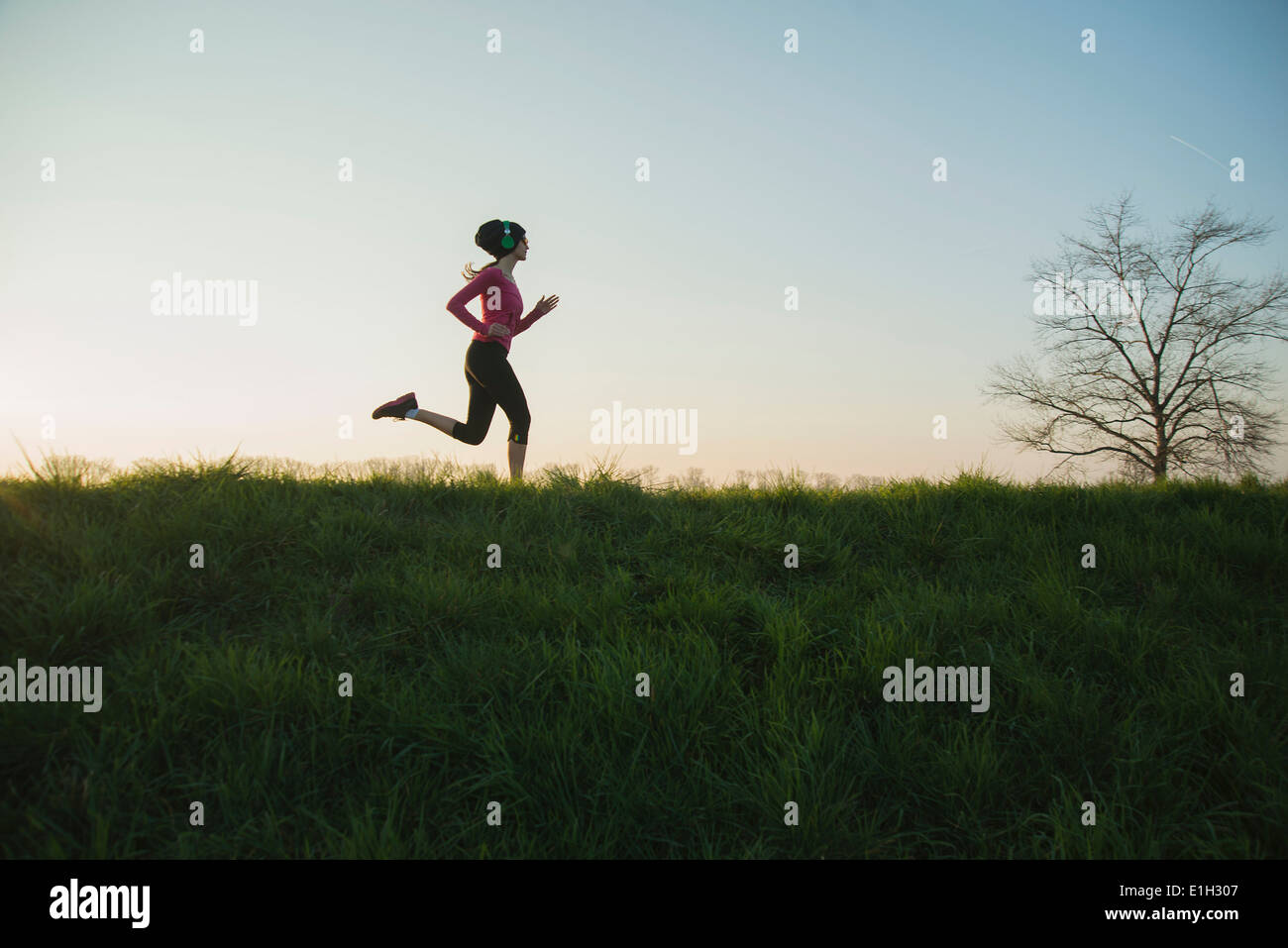 Junge weibliche Läufer Silhouette auf Hügel Stockfoto