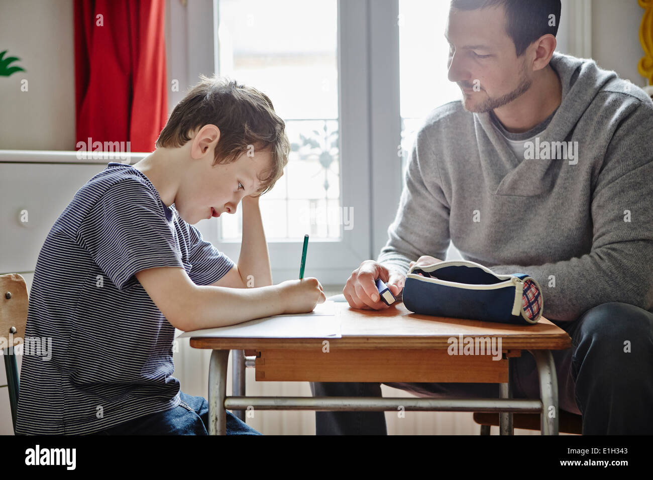Vater helfen Sohn bei den Hausaufgaben Stockfoto