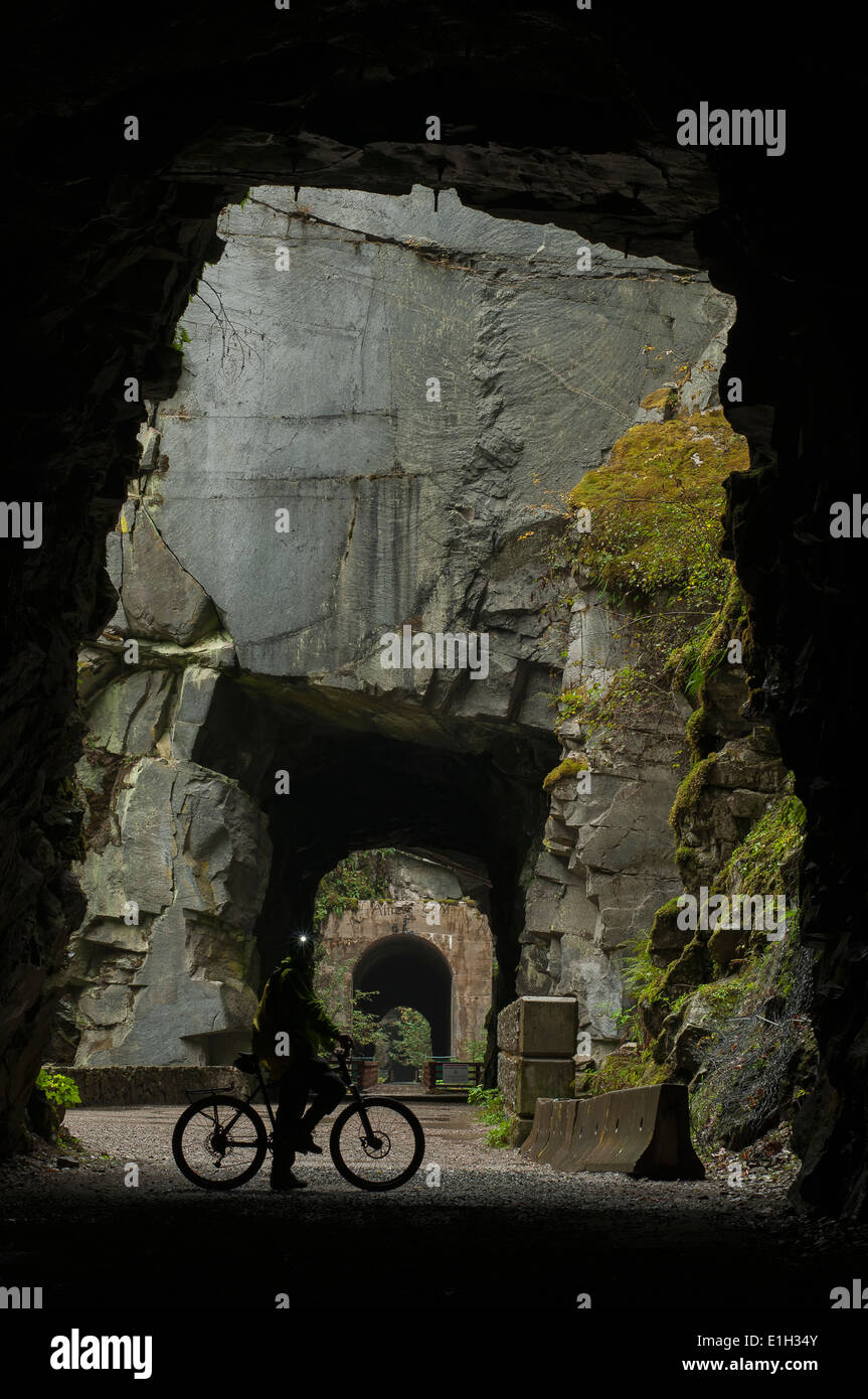 Radfahrer im Inneren eines Othello Tunnels, Coquihalla Provincial Park, "KVR" Trail, Trans-Canada-Trail, British Columbia, Kanada Stockfoto