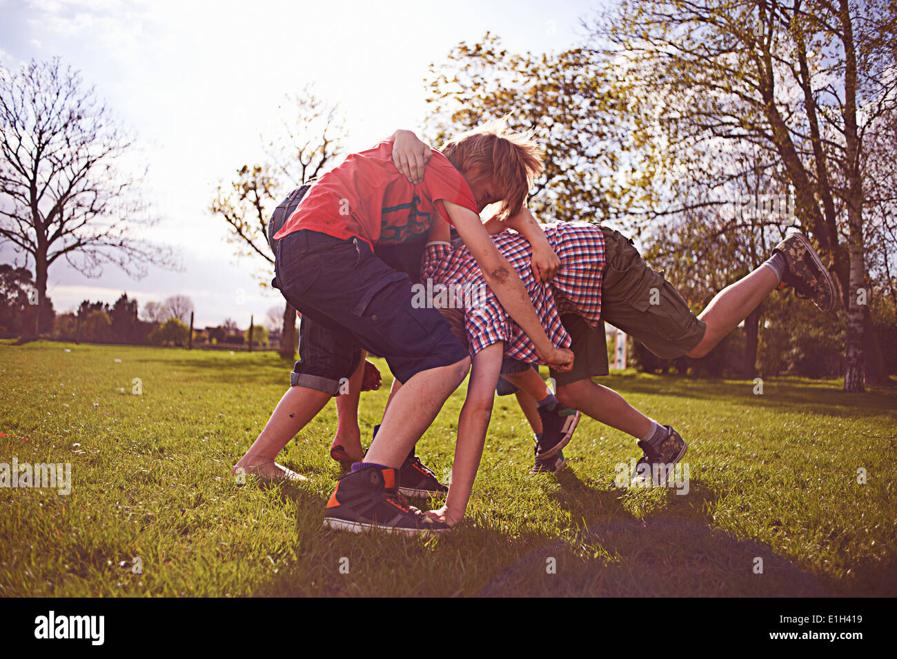 Jungen spielen kämpfen am Spielfeld Stockfoto