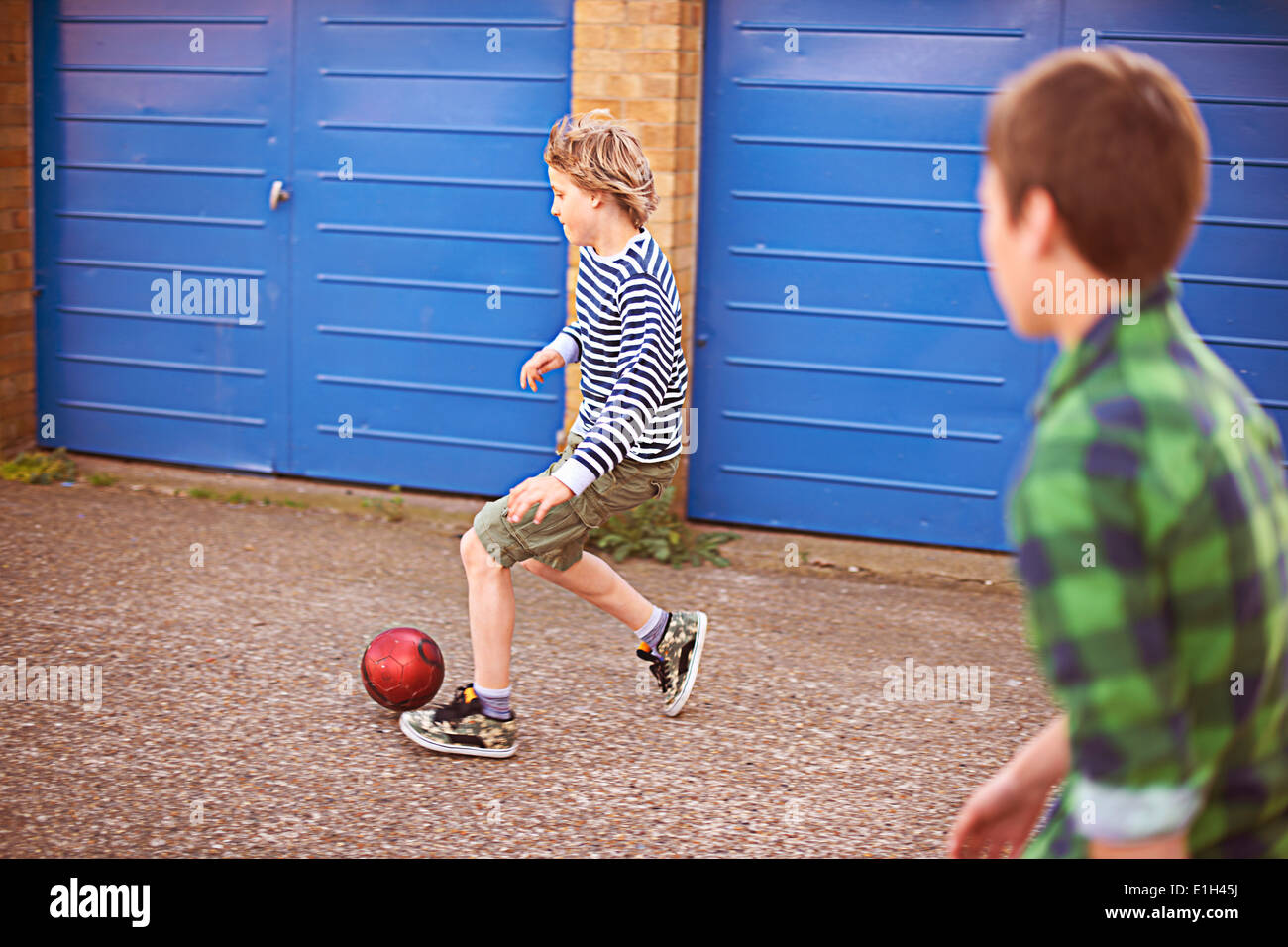 Zwei Jungs spielen Fußball mit garage Stockfoto