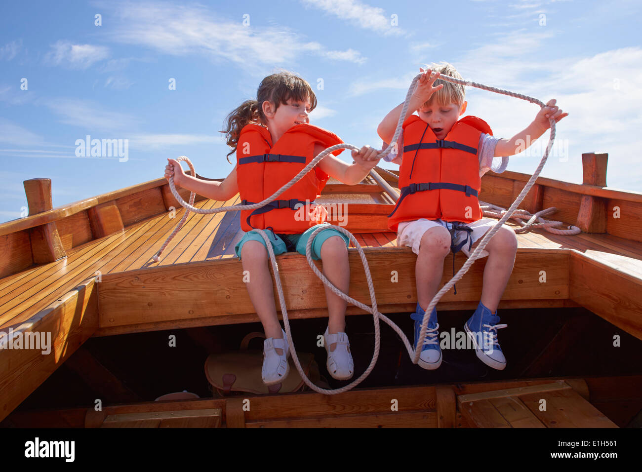 Zwei Kinder sitzen im Boot, mit Seil Stockfoto