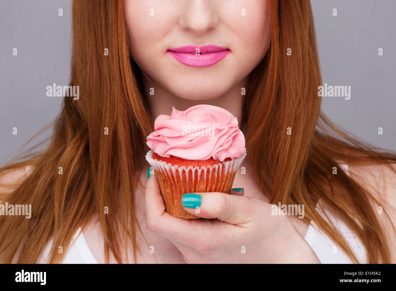 Bild junge Frau mit Cupcake beschnitten Stockfoto