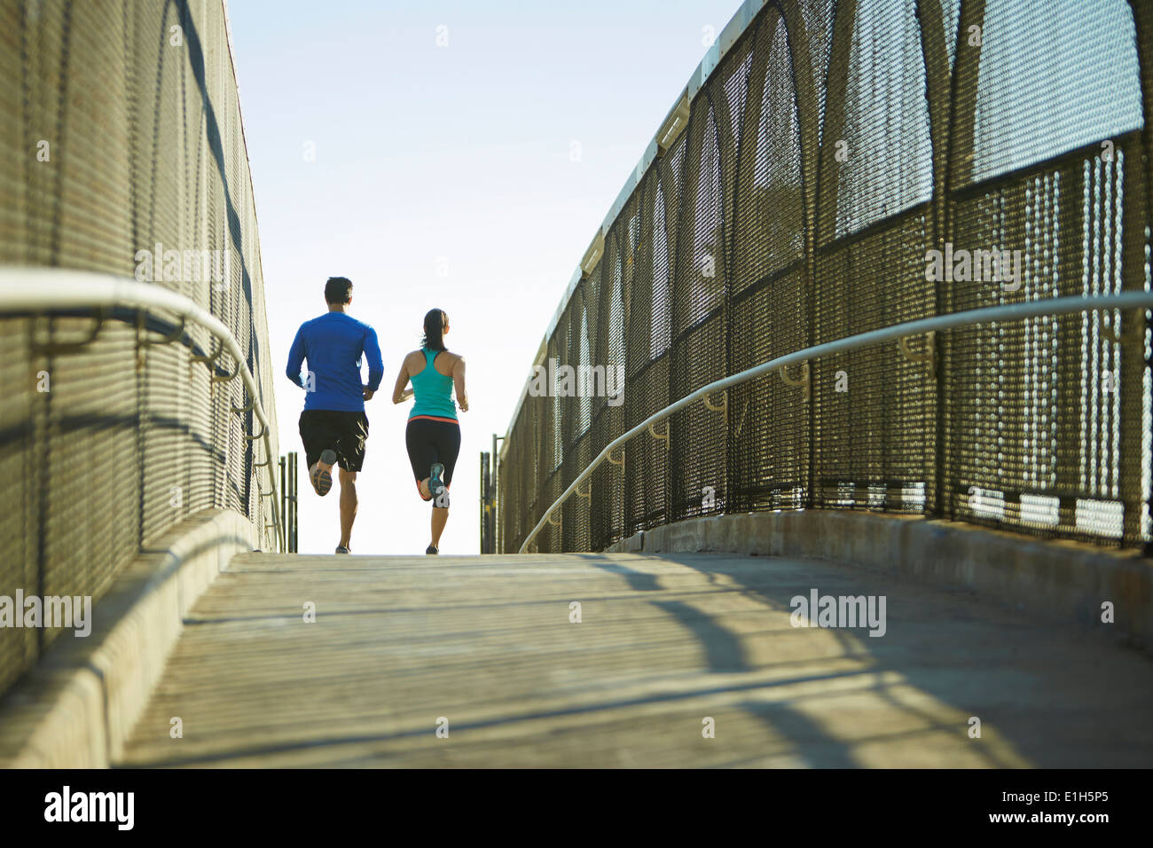Mann und Frau laufen über Brücke Stockfoto