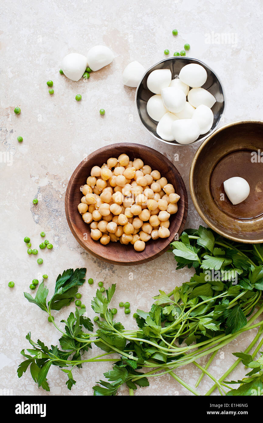 Essen-Stilleben mit Schalen aus Kichererbsen, Mozzarella und Petersilie Stockfoto