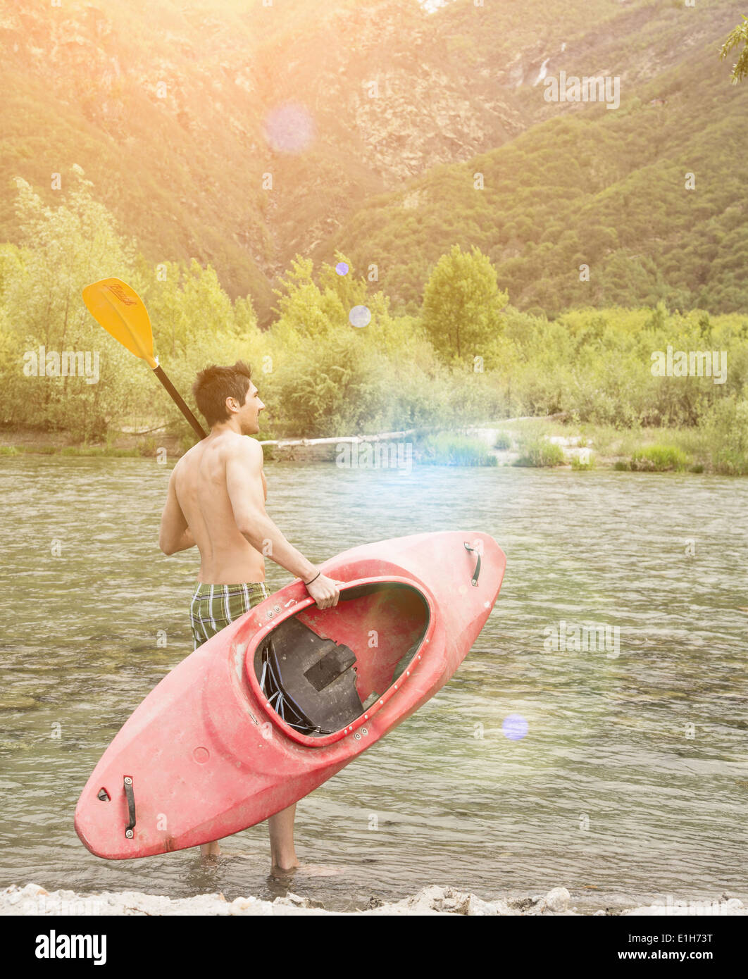 Junger Mann mit Kanu auf Toce Flussufer, Piemont, Italien Stockfoto