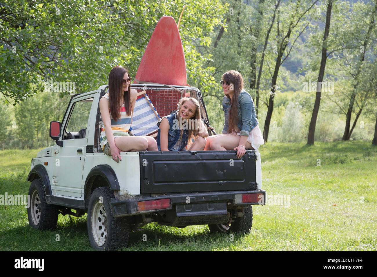 Freunde sitzen auf Rückseite des Geländewagen Stockfoto