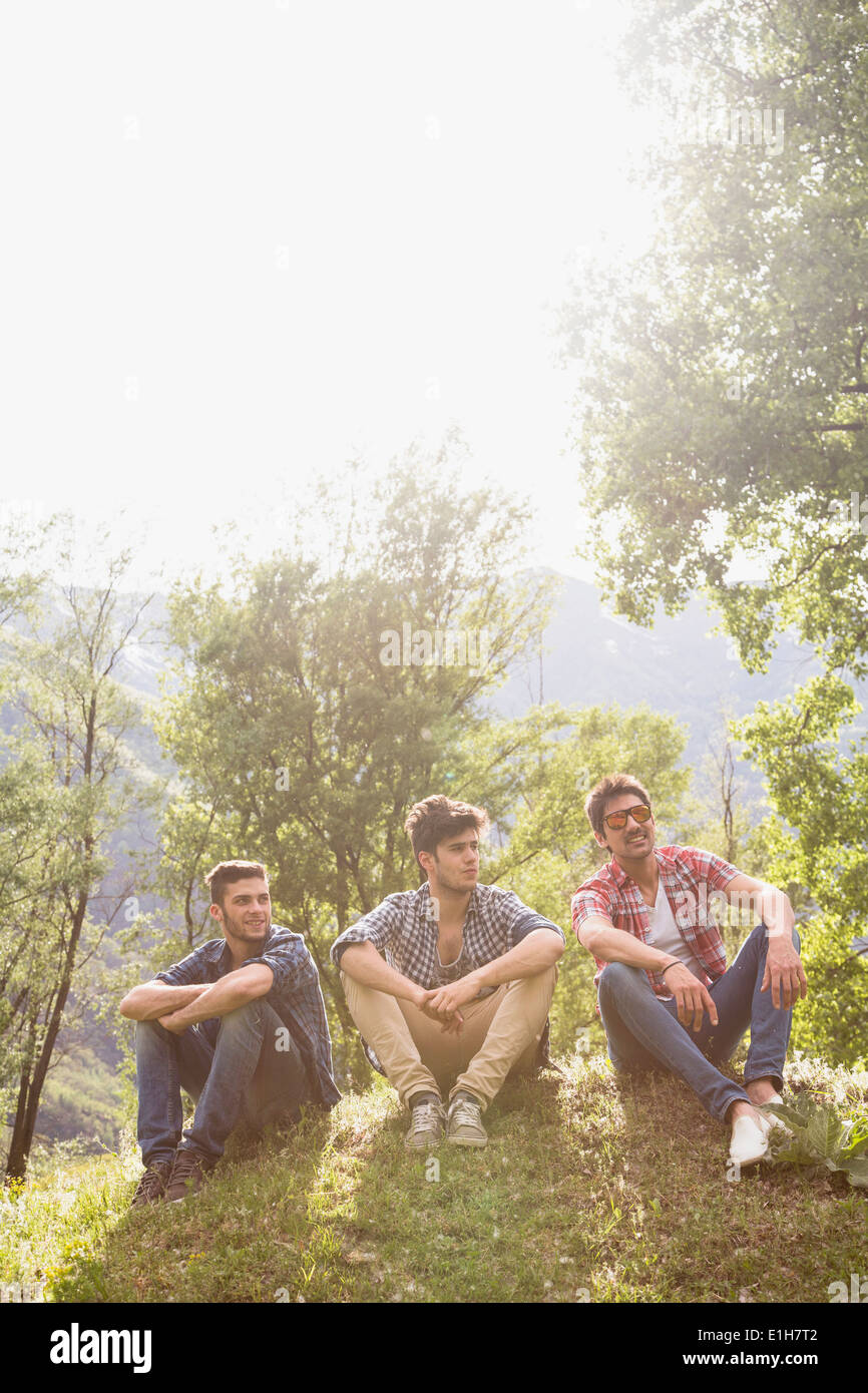 Drei junge Männer sitzen auf dem Rasen Stockfoto