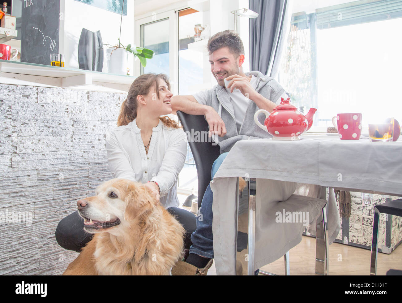 Junges Paar beim Frühstück, mit Hund Stockfoto