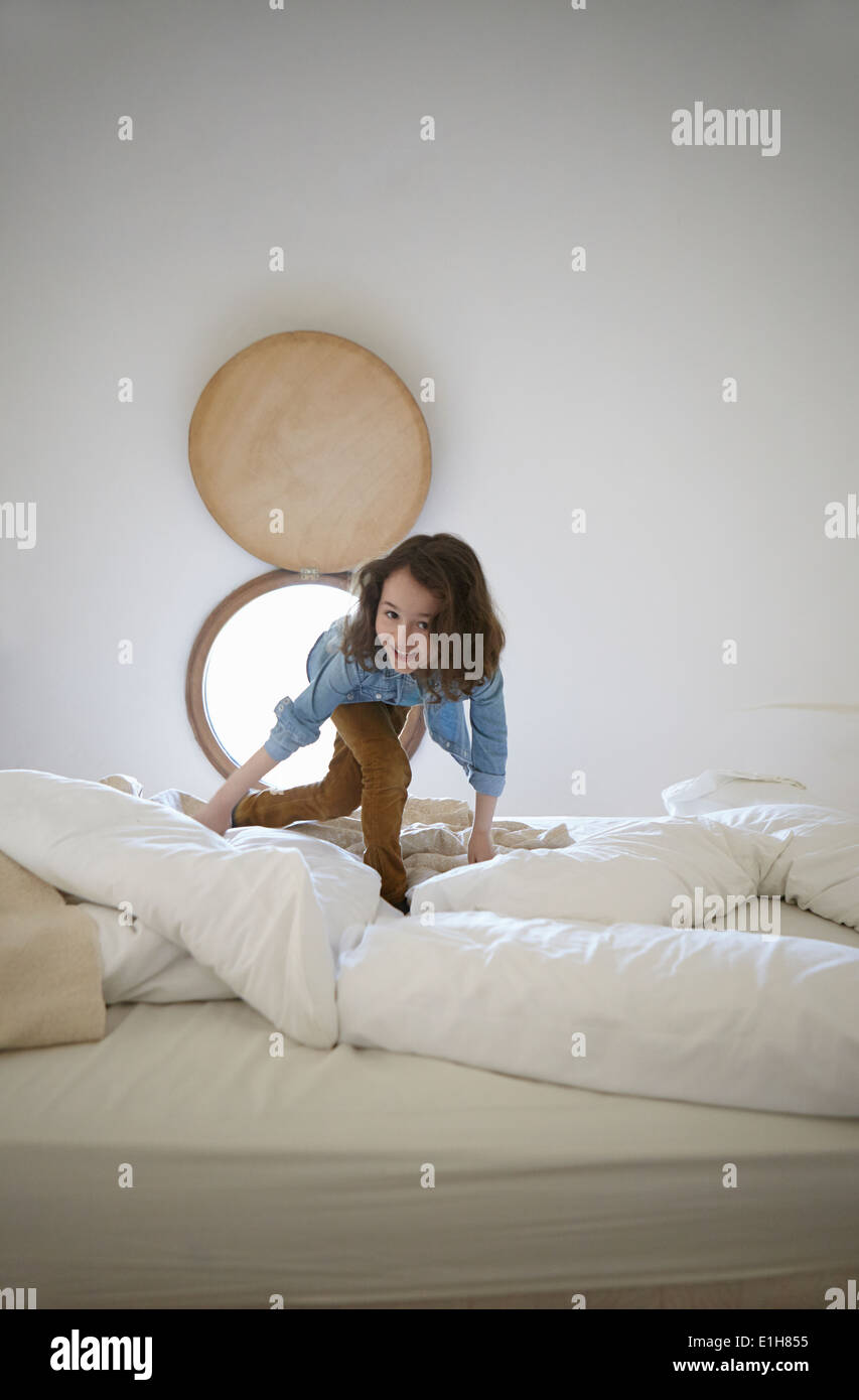 Ehrliches Porträt von Mädchen spielen auf Bett Stockfoto
