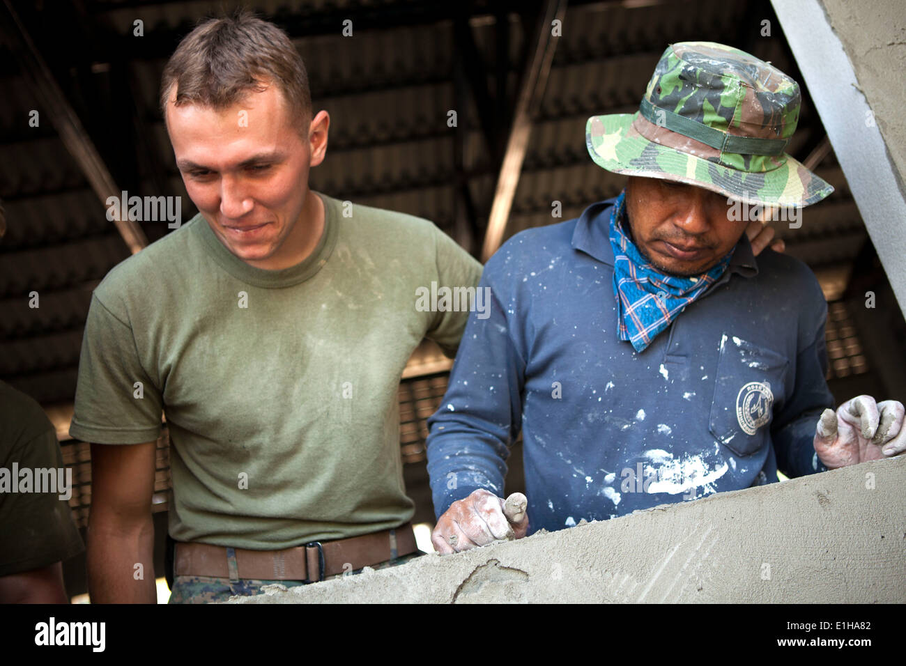 Manat Jeewoinbhlom, links, einem lokalen Freiwilligen und U.S. Marine Corps Lance Cpl. Michael Masontait, rechts, mit Marine Wing Suppor Stockfoto