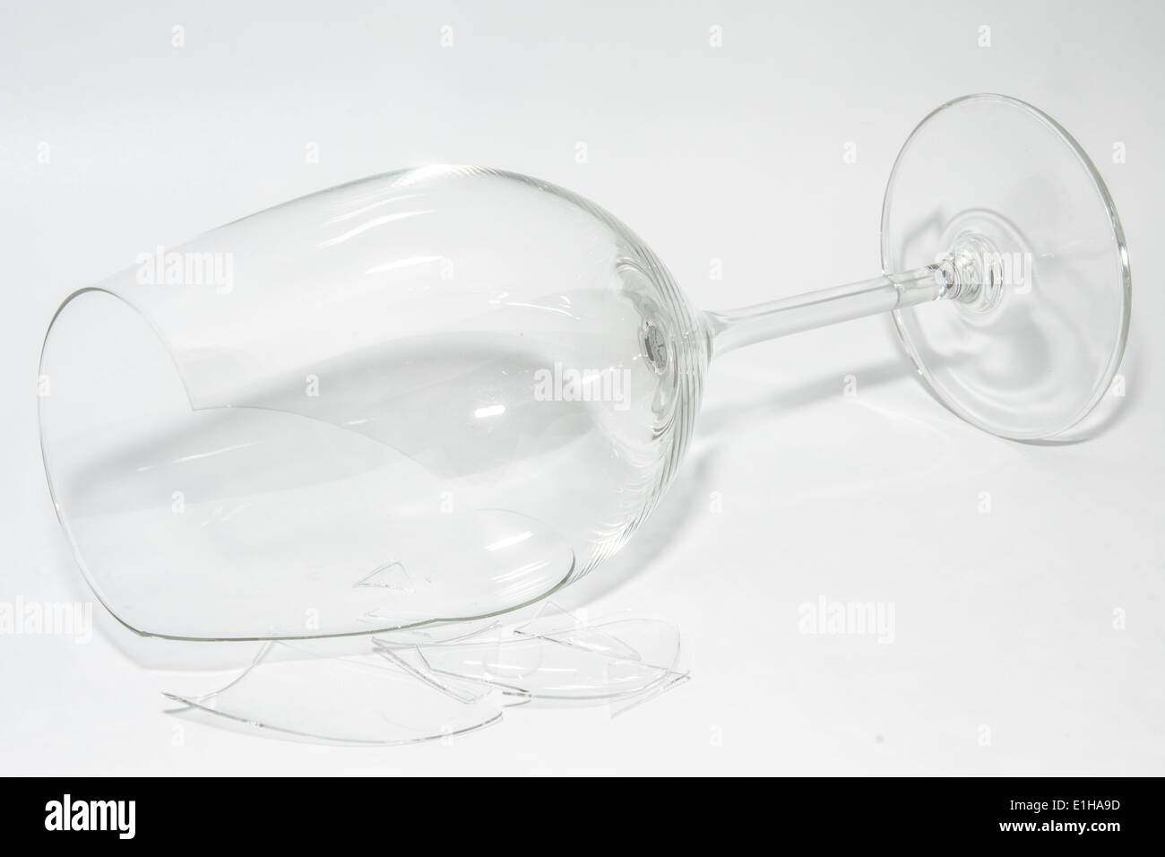 Zerstörte kaputte Weinglas mit scharfen Scherben liegen auf weißem Hintergrund Stockfoto
