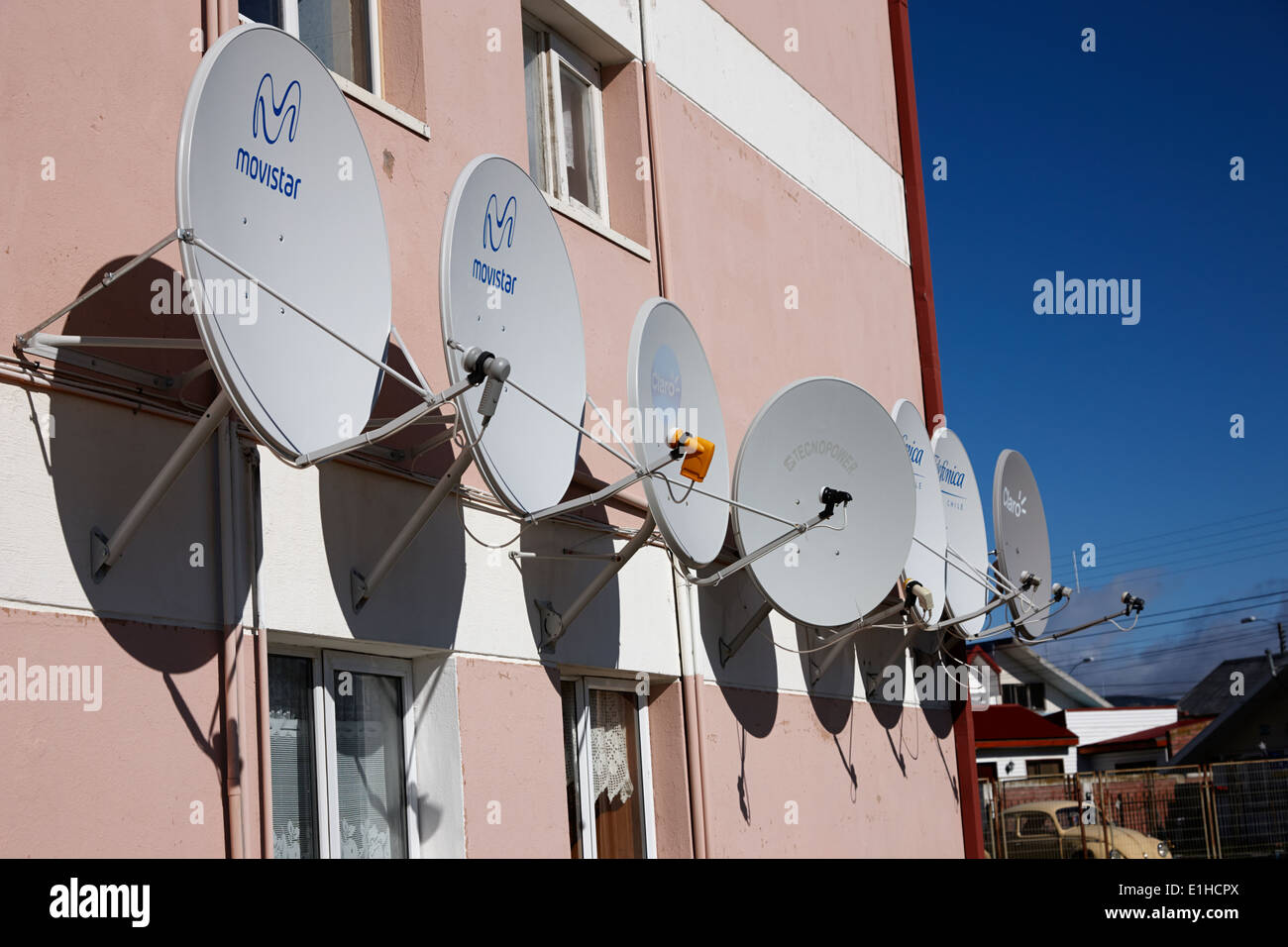 Haushalt TV Satellitenschüsseln mit niedrigen Winkel montiert auf Wohnung Wand-Punta Arenas, Chile Stockfoto