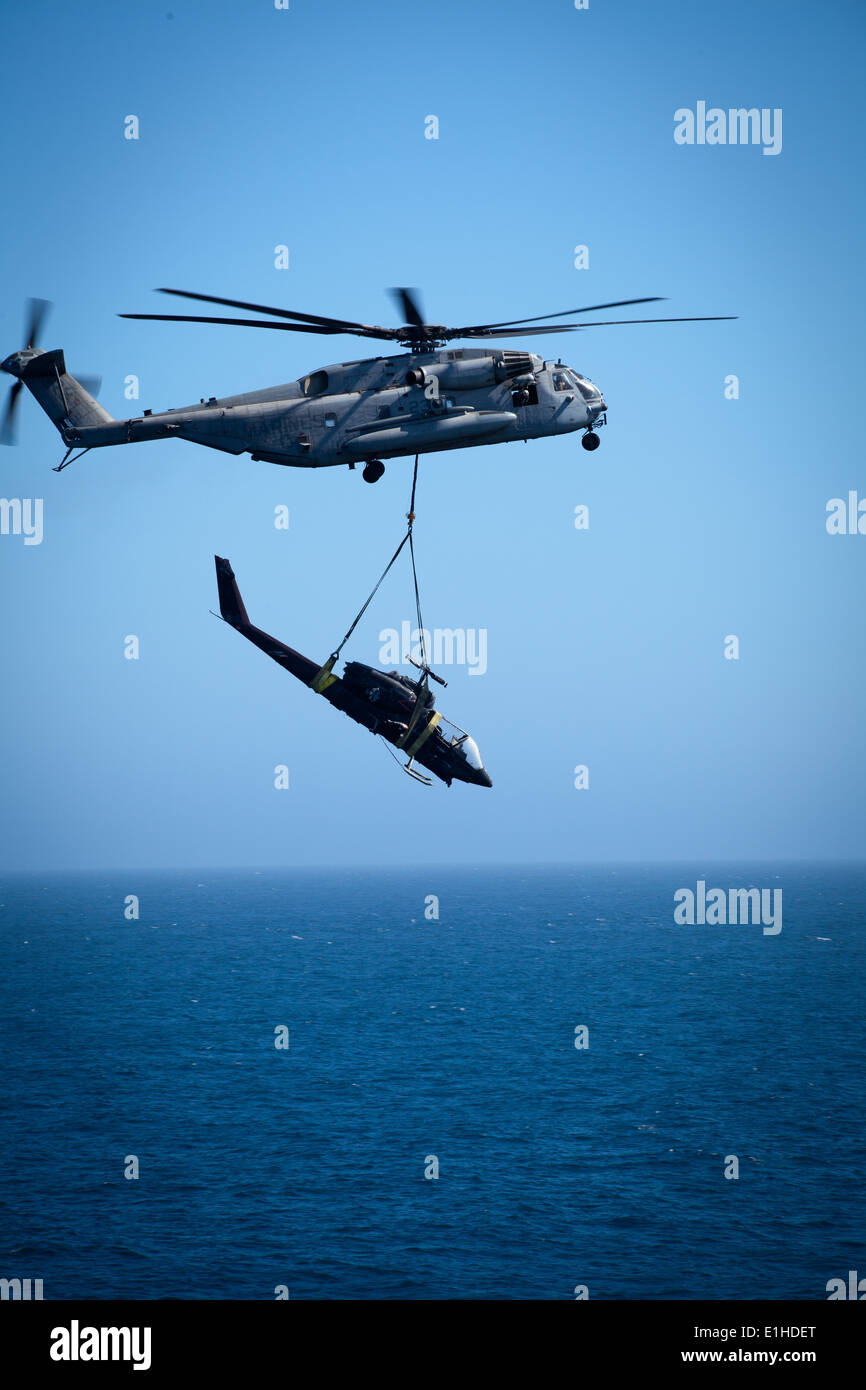 Ein US-Marinekorps CH-53E Super Stallion-Hubschrauber zugewiesen, Marine Medium Helicopter Squadron (HMM) 364 transportiert ein AH-1 Stockfoto