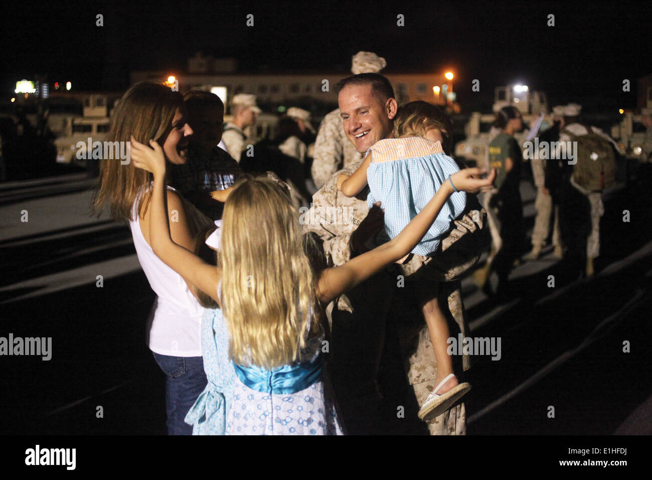 US Marine Corps Master Sgt. Brannon A. Niesent ist im Camp Foster in Okinawa, Japan, von seiner Familie 19. August 2012, bei begrüßt. Stockfoto