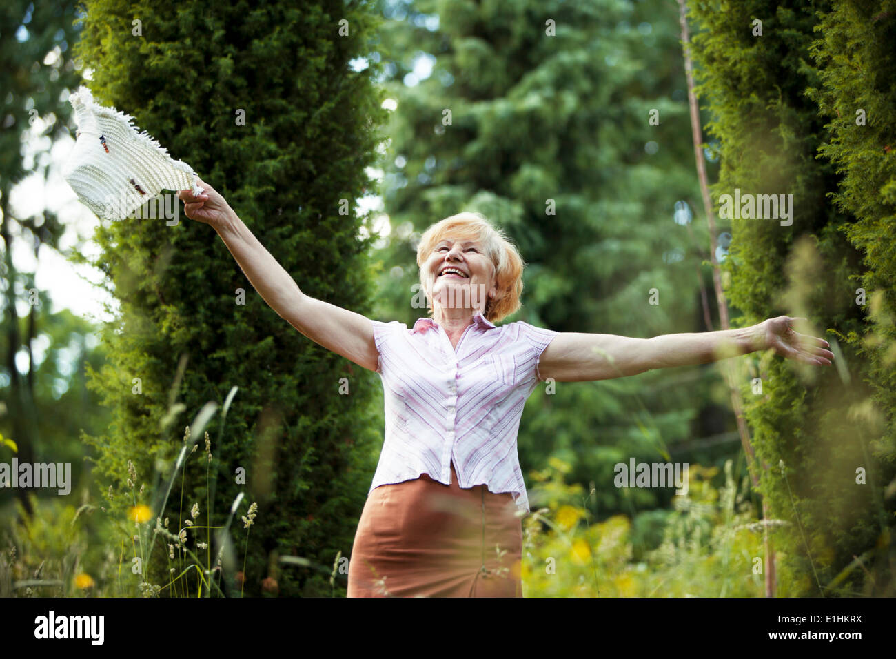 Freiheit. Glückliche alte Dame mit Hut lächelnd in The Garden. Lebensstil Stockfoto
