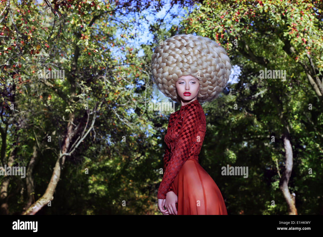 Mode-Stil. Kreativität. Exzentrische Frau in Kunst-Perücke mit Zöpfen Stockfoto