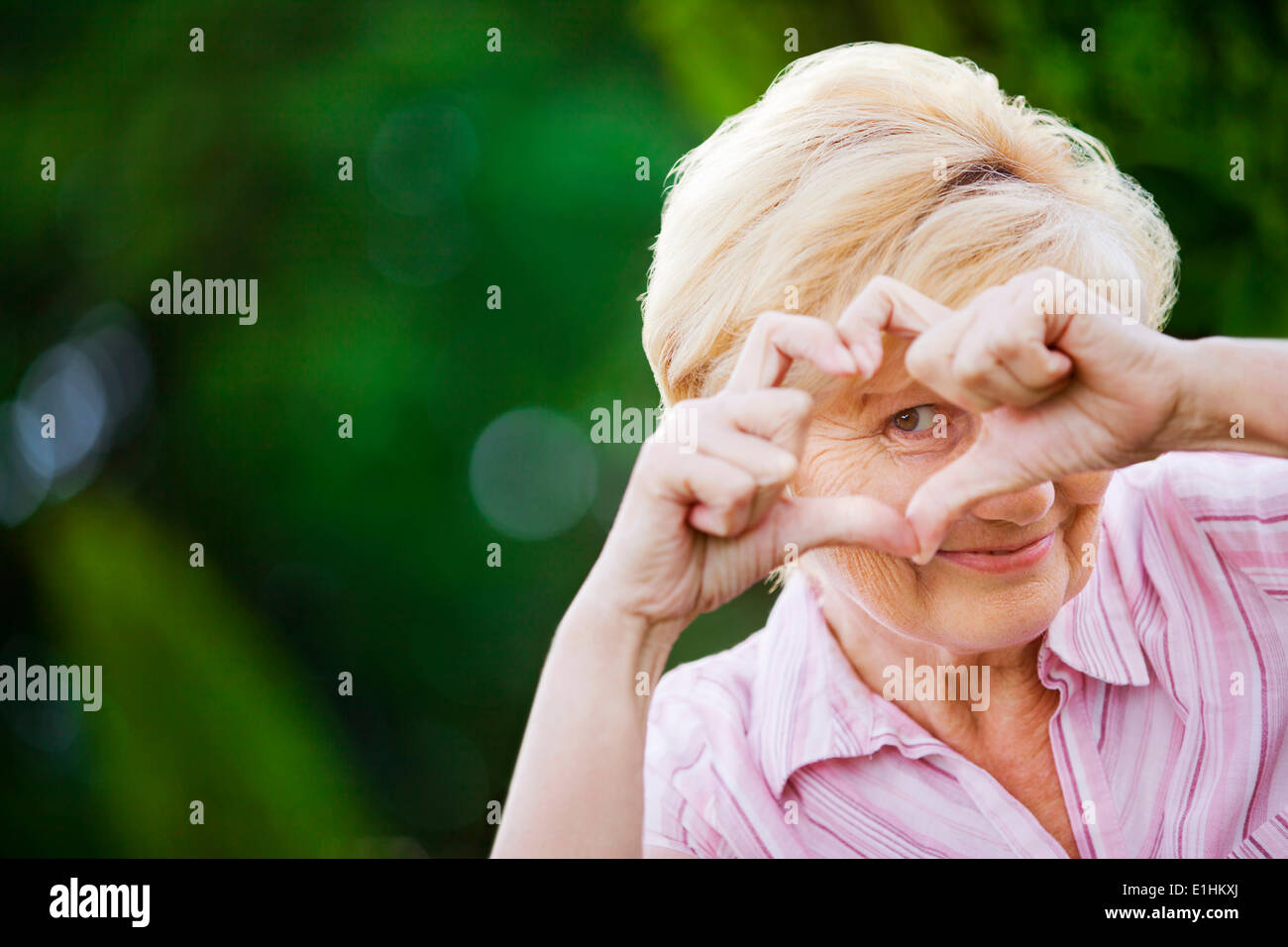 Positivität. Glücklich lustig Senior Woman mit Symbol des Herzens Stockfoto