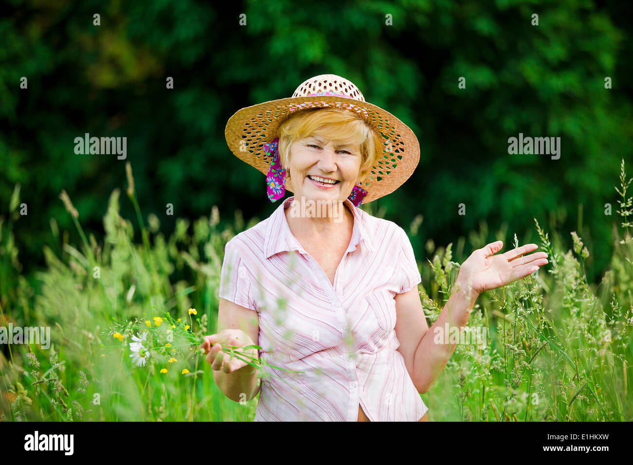Freude. Freundlichen glücklich Reife Frau in Strohhütte mit gestreckten Armen Stockfoto