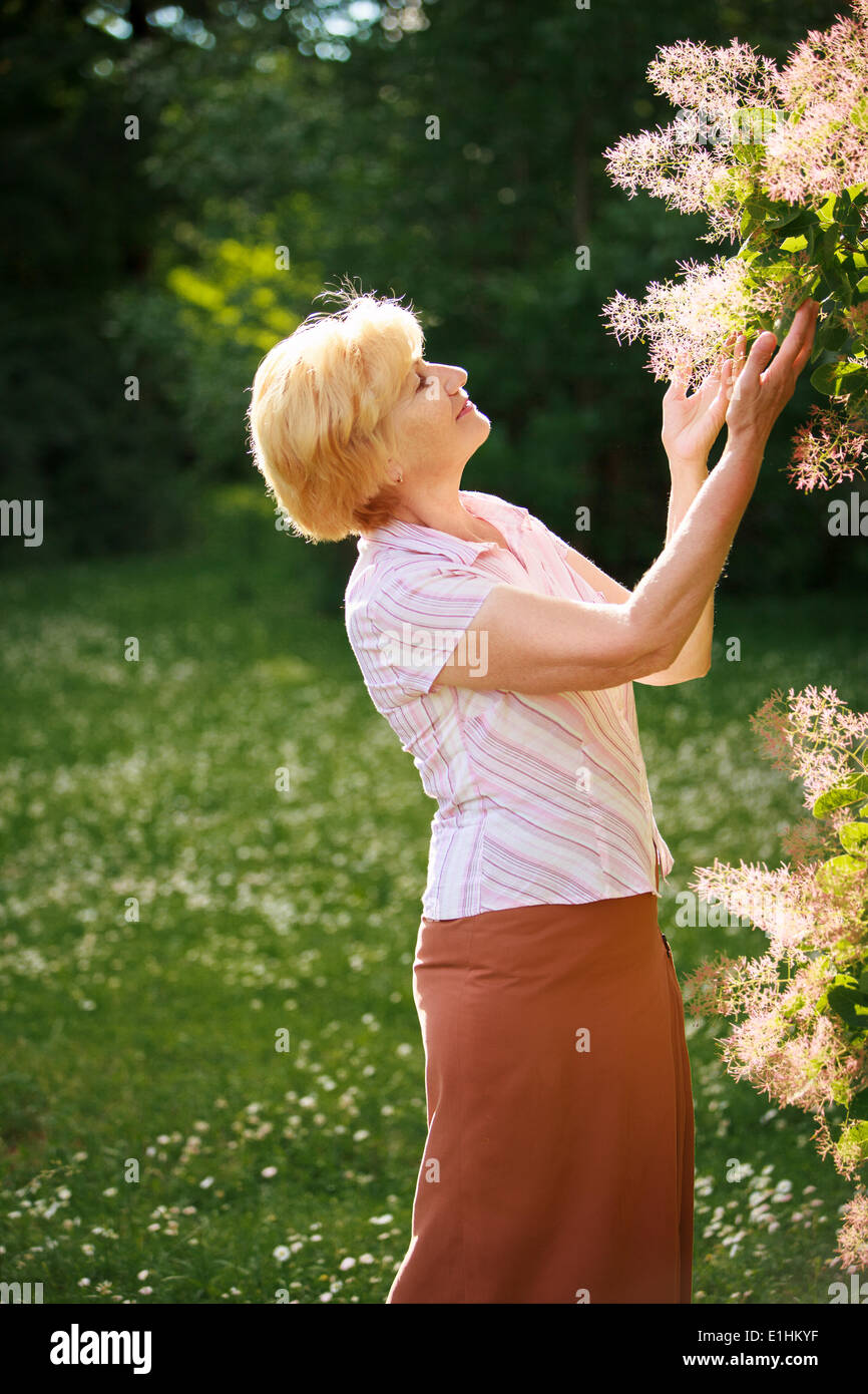 Gartenarbeit. Gnädige Frau Senior und Blumen Stockfoto