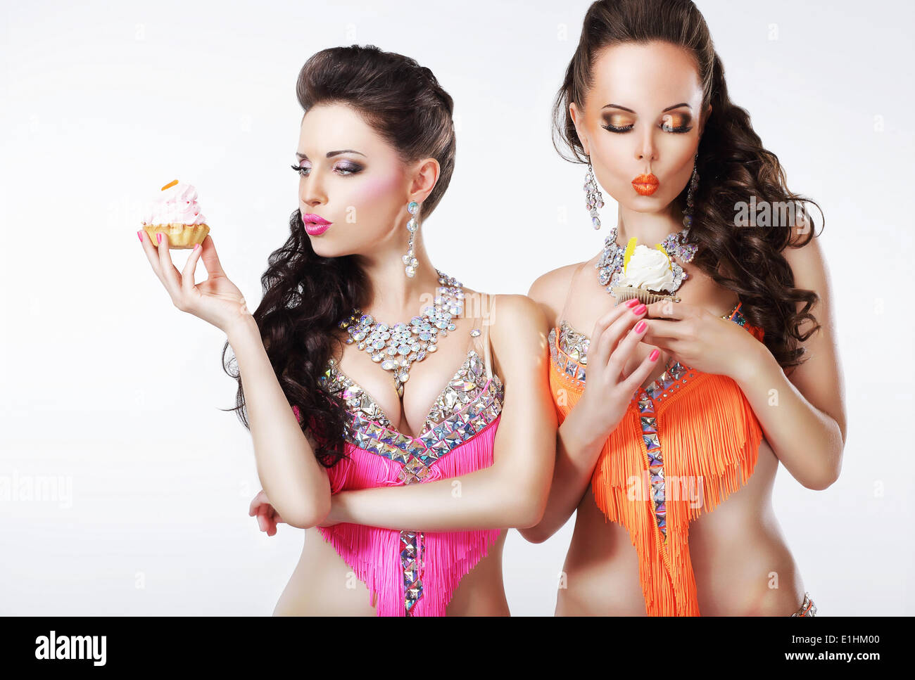 Vorgeschmack auf. Zwei Frauen mit leckeren Cupcakes mit Schlagsahne Stockfoto