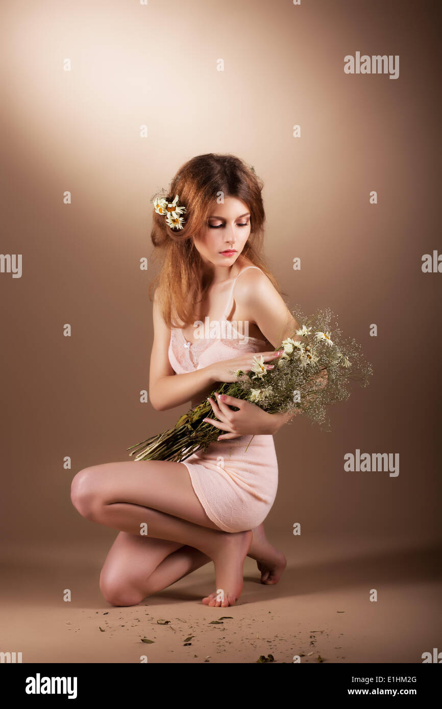 Sentimental Auburn barfuß Frau entspannend mit Wildblumen Stockfoto