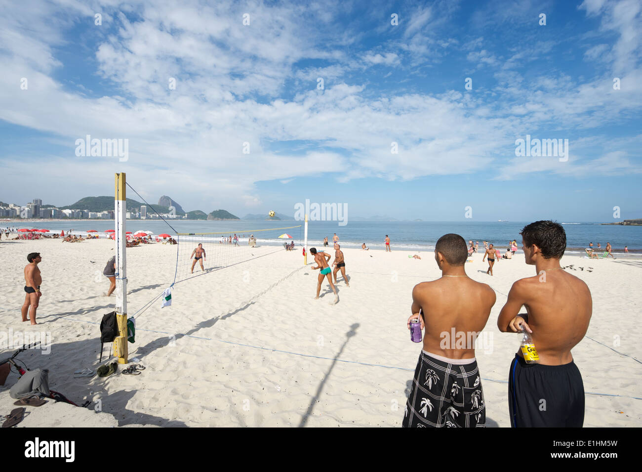 RIO DE JANEIRO, Brasilien - Januar 2011: Junge brasilianische Männer beobachten ein Spiel der Footvolley, ein Sport von Fußball und Volleyball. Stockfoto