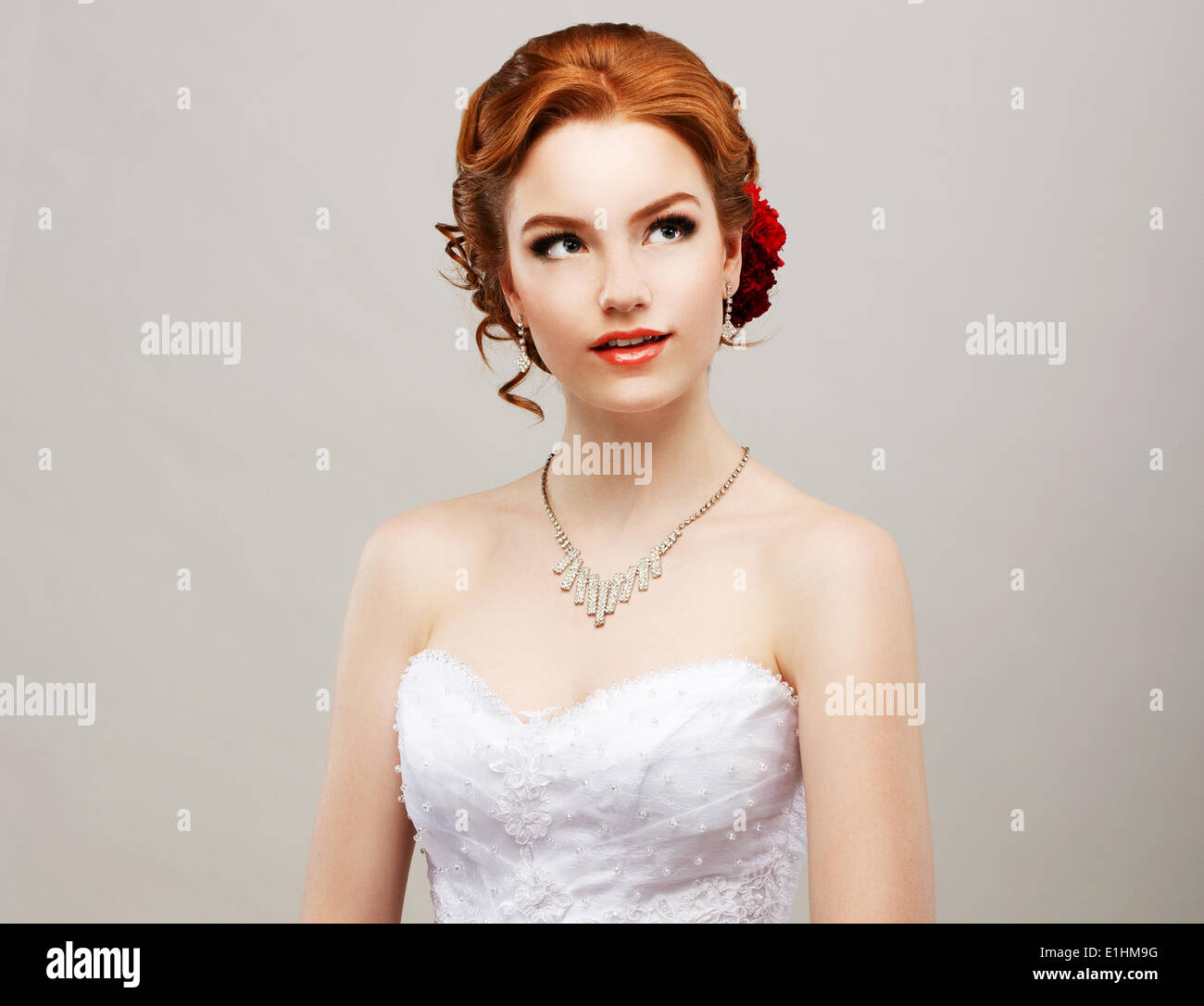 Sentimentalität. Romantische rote Haare Frau mit Blume in ihrem Kopf. Weiblichkeit Stockfoto