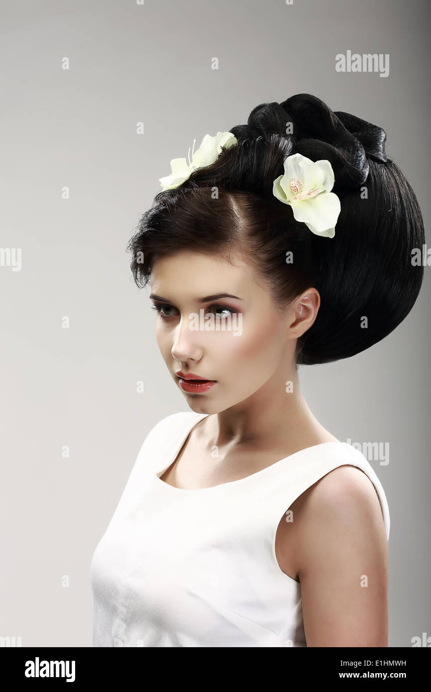 Gesicht der schöne Brünette Braut Mode-Modell. Elegante Frisur mit frühlingshaften Blumen Stockfoto