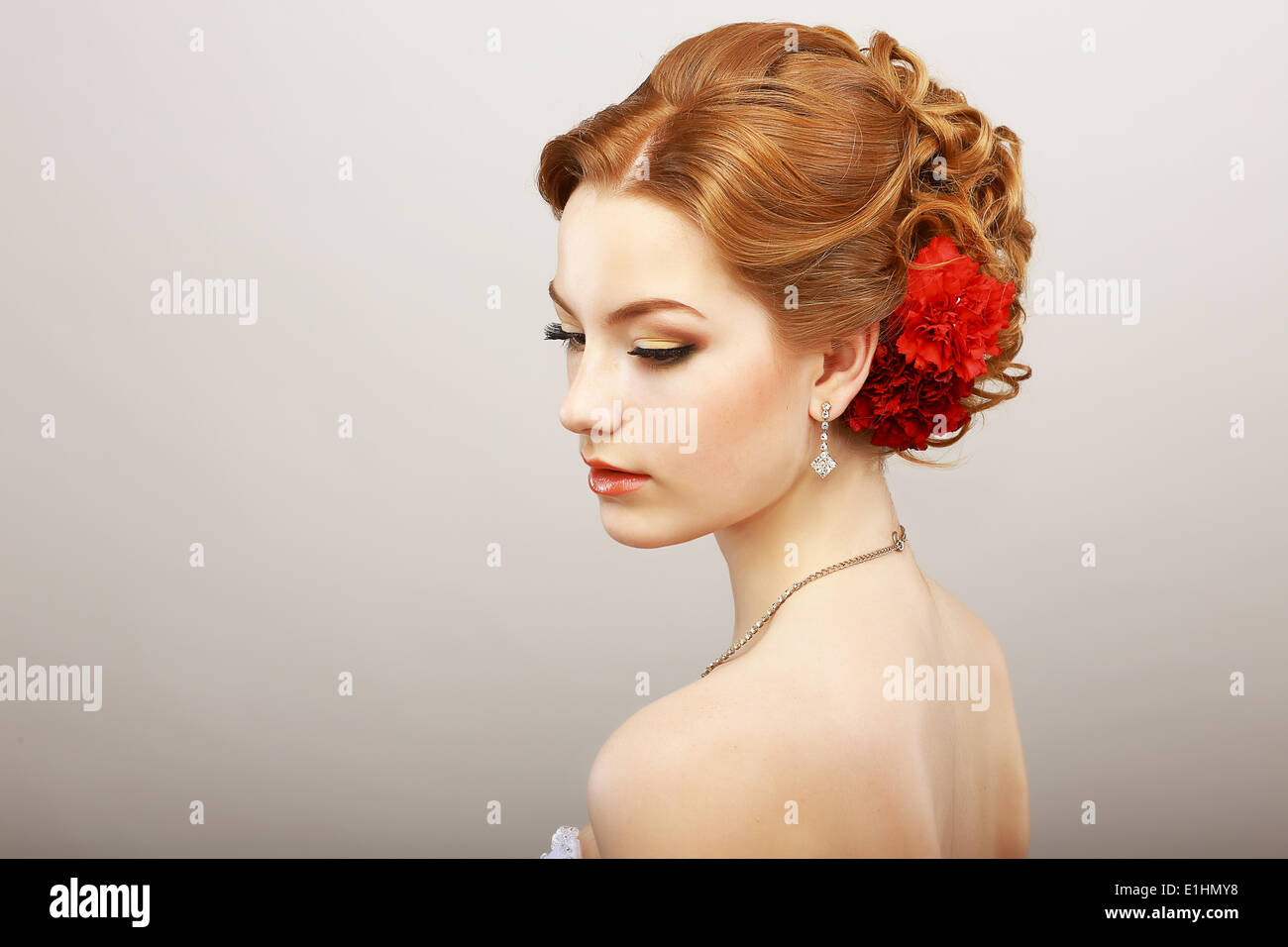 Tagtraum. Zärtlichkeit. Goldenes Haar Weibchen mit rote Blume. Platin Glanz Halskette Stockfoto