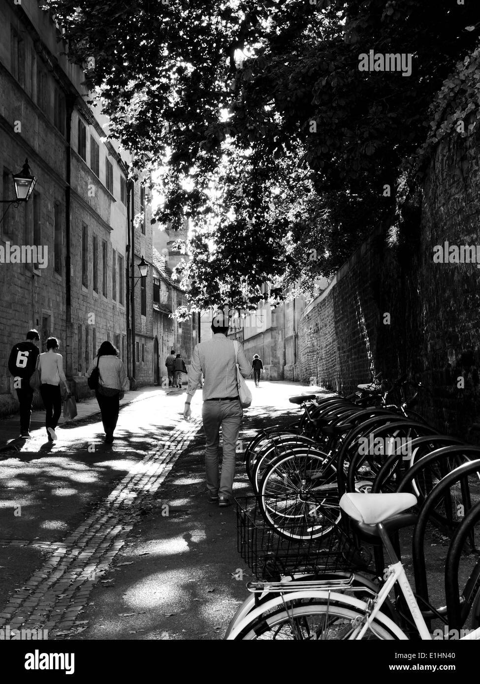 Eine gepflasterte Straße in Oxford mit abgestellten Fahrrädern und Menschen zu Fuß entlang Stockfoto