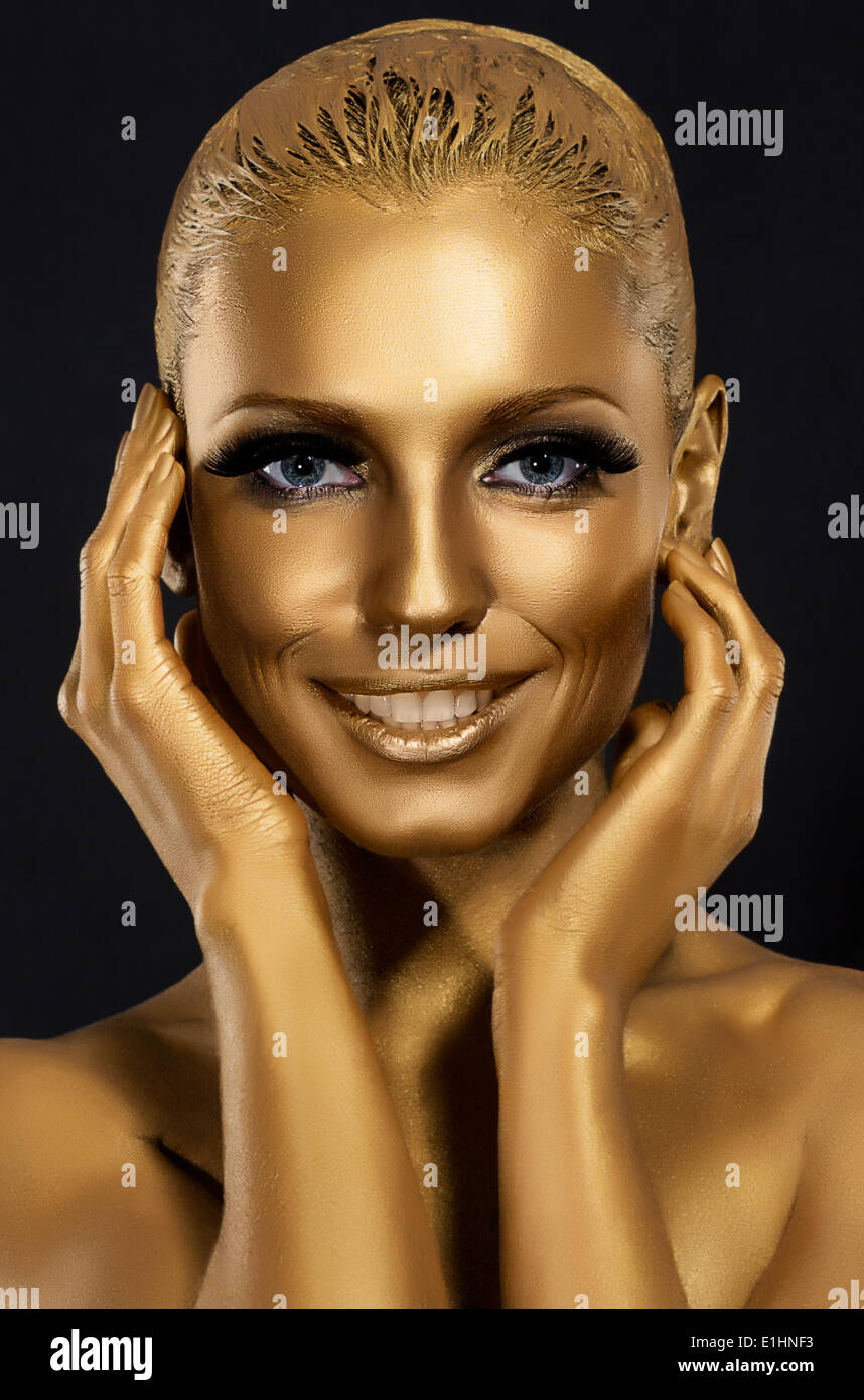 Färbung & Blick. Wunderschöne Frau lächelnd. Fantastische Goldene Make-up. Kunst Stockfoto