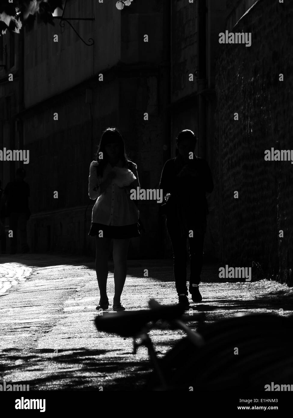 Silhouette Menschen auf eine teilweise gepflasterten Straße in Oxford in heller Sonne Stockfoto