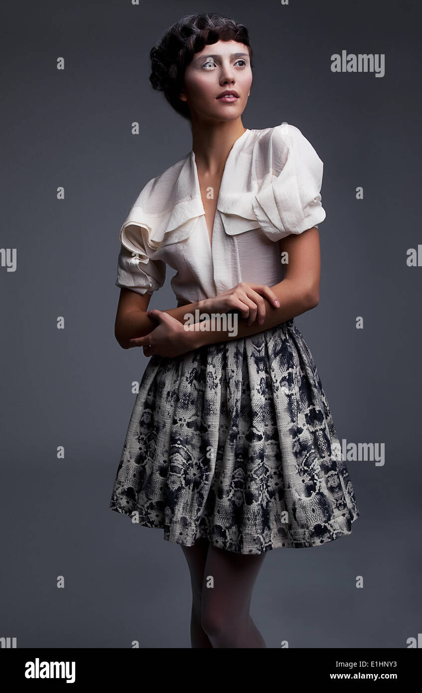 Spektakuläre junge modische Mädchen stehend im grauen Rock und weißer Bluse - Retro-Stil Stockfoto