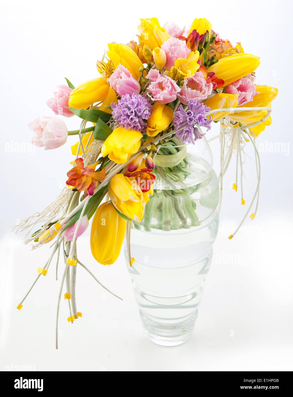 Bunter festlichen Strauß Frühlingsblumen in Glasvase auf weißem Hintergrund Stockfoto
