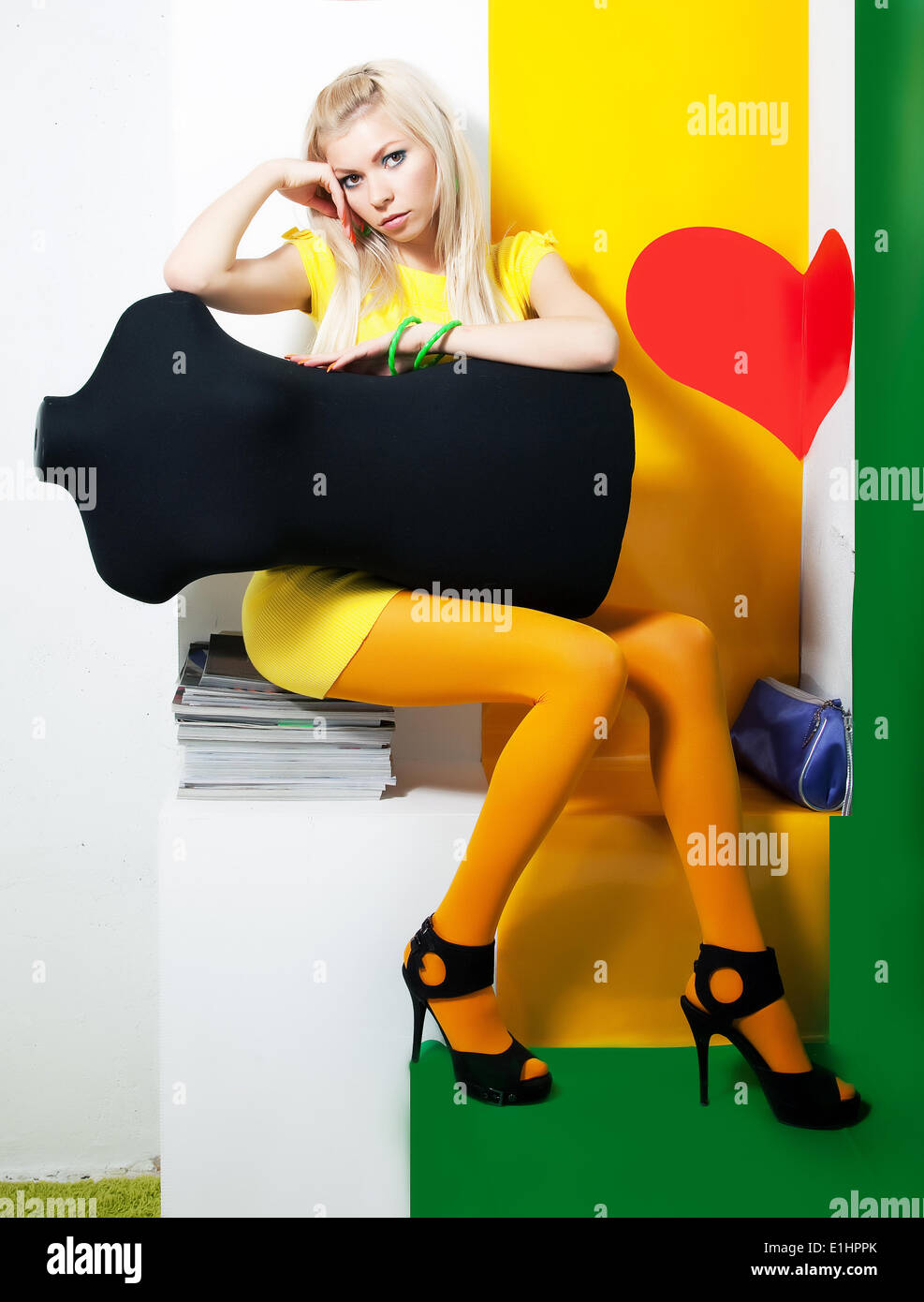 Elegante Frau blondes Haar posiert im Studio mit schwarzen mannequin Stockfoto