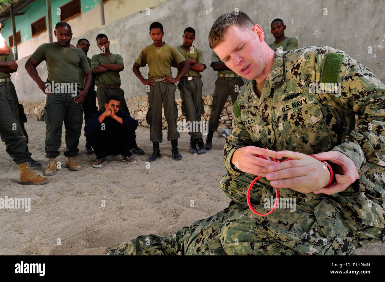 US Navy Chief Master-at-Arms Neil McLean, eine maritime zivile Angelegenheiten und Sicherheit Training Ausbilder demonstriert Handschellen Stockfoto