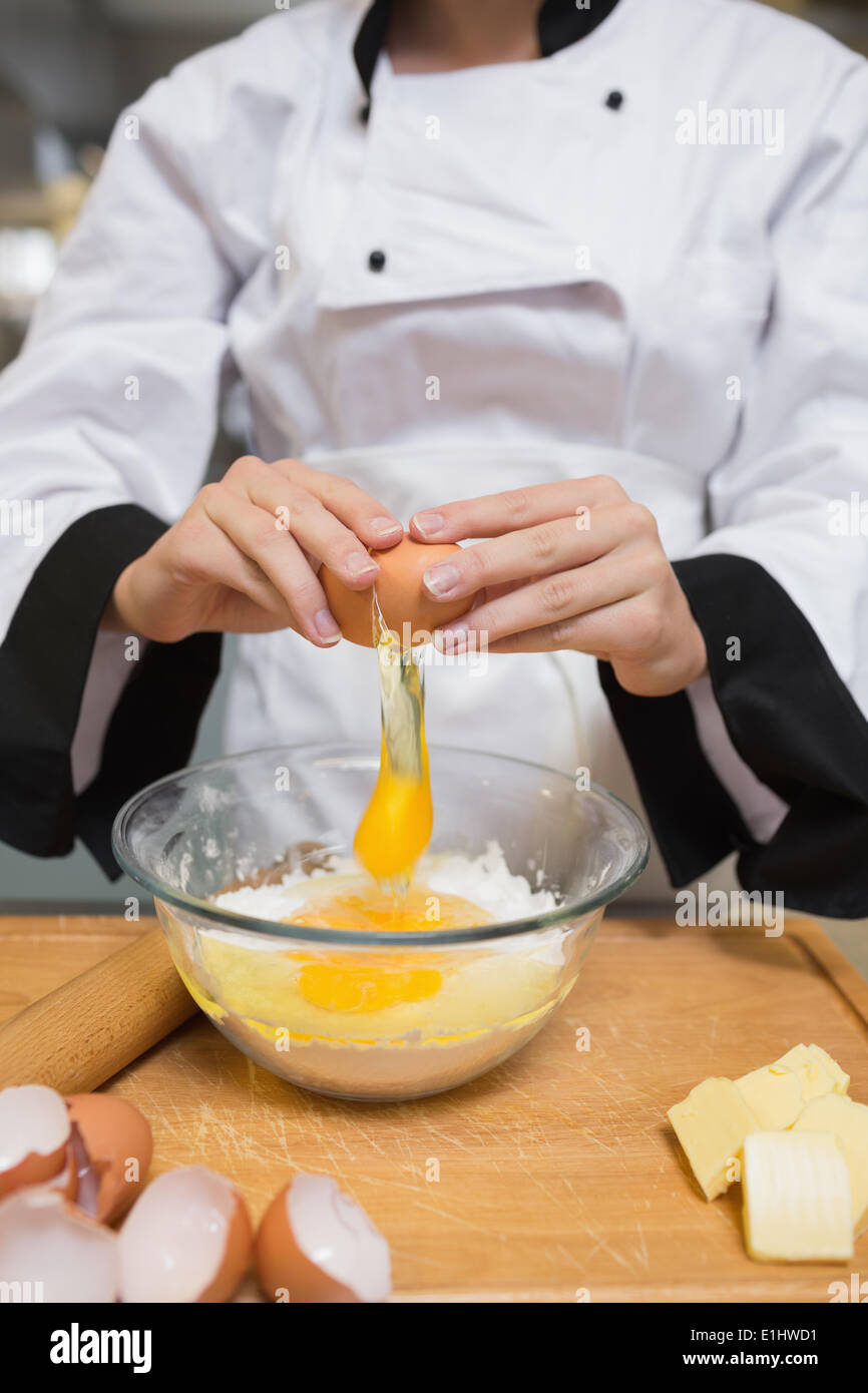 Koch brechen Eiern zu Mehl Stockfoto